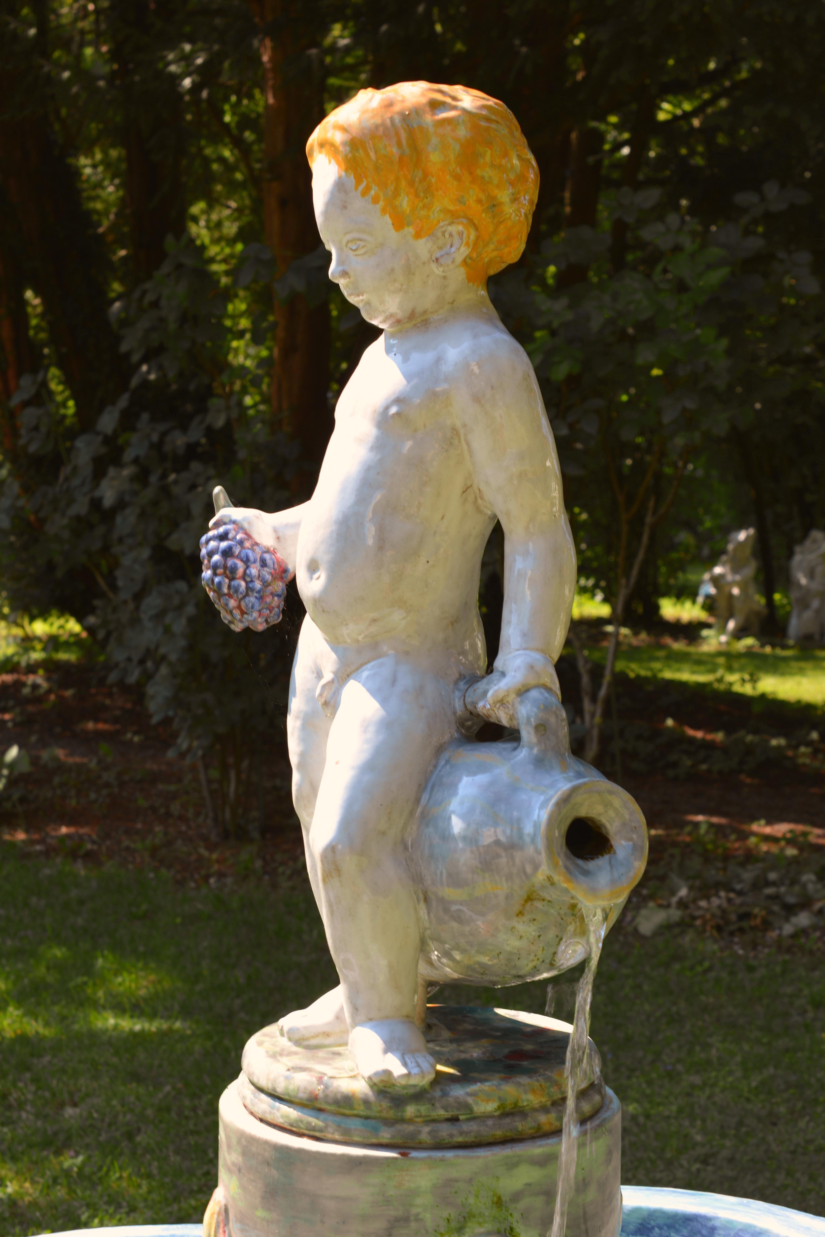 Cette figurine en majolique, peinte à la main, représentant un garçon avec une cruche, est fabriquée dans les studios de la Manufacture de porcelaine de Nymphenburg à Munich, en Allemagne. Ils créent des figurines faites à la main selon la technique