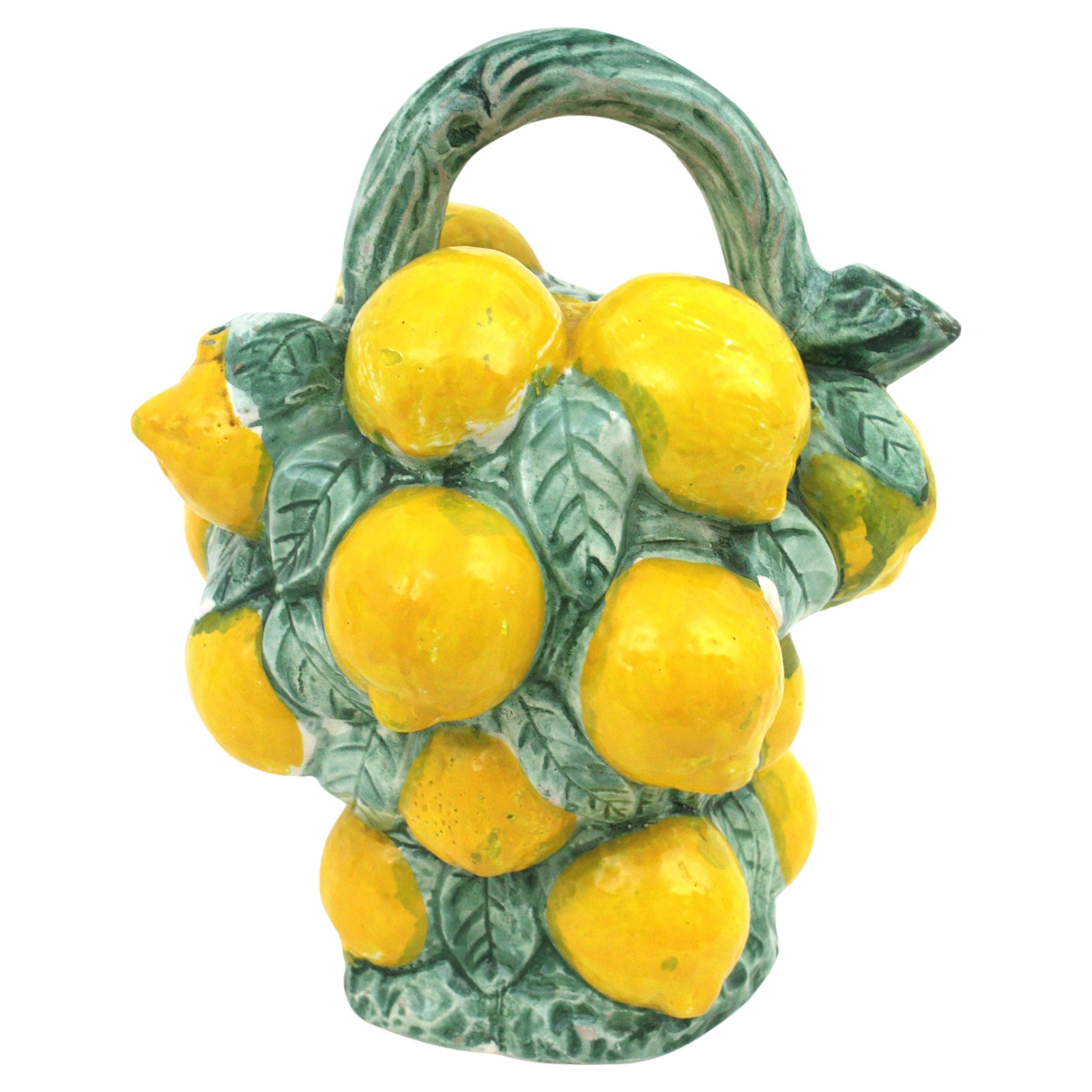 Eye-catching realistic Majolica lemons jug / pitcher in multicolor glazed ceramic,  Spain, 1950s-1960s.
Hand-painted Manises ceramic decorative jug in the shape of a bunch of lemons in green and yellow glazed ceramic.
A cool accent to any kitchen or