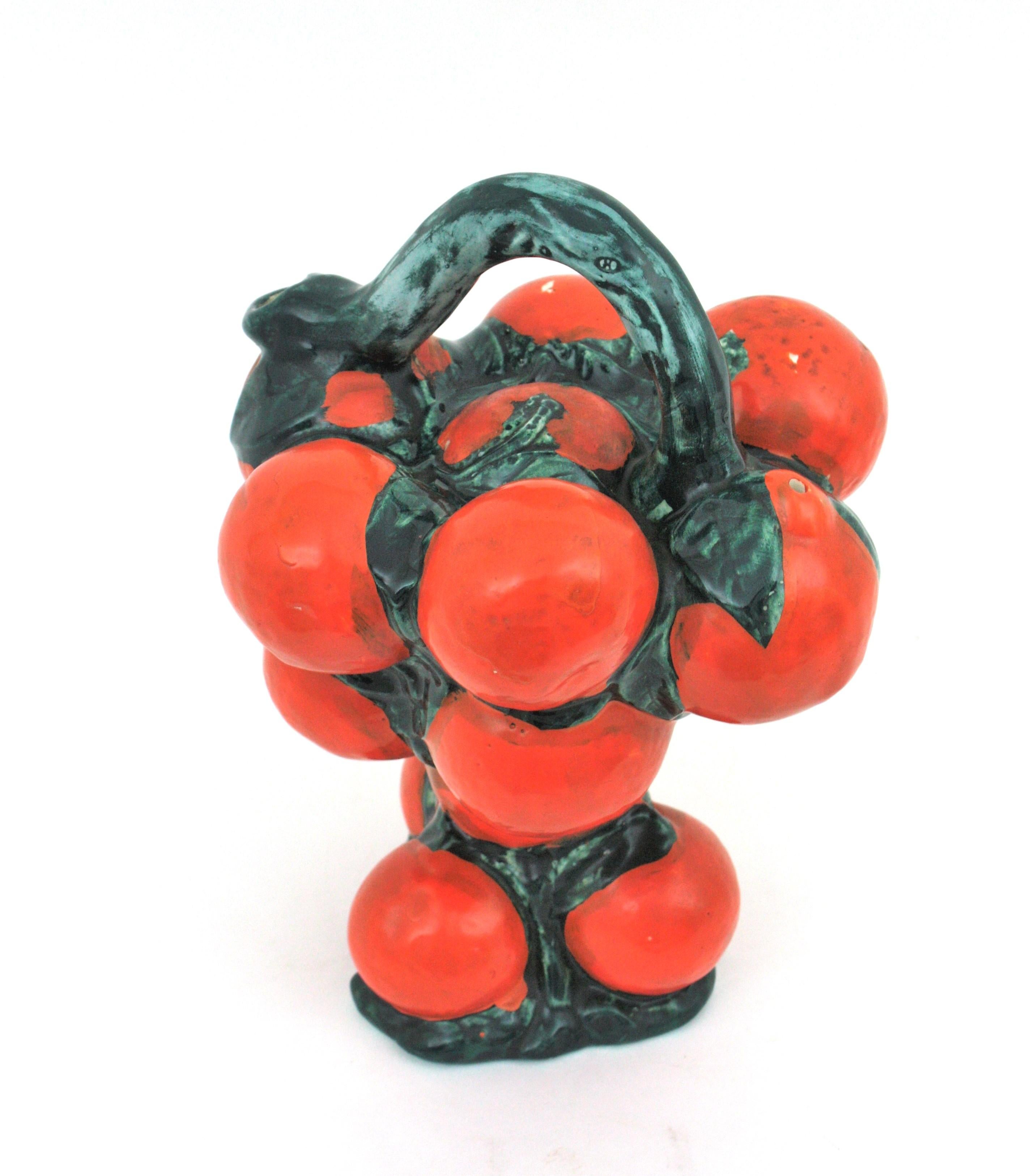 Auffallend realistischer Majolika-Krug aus orangefarbener und grün glasierter Keramik,  Spanien, 1950er-1960er Jahre.
Handbemalte dekorative Keramikkanne von Manises in Form eines Orangenstraußes.
Ein cooler Akzent für jede Küche oder als