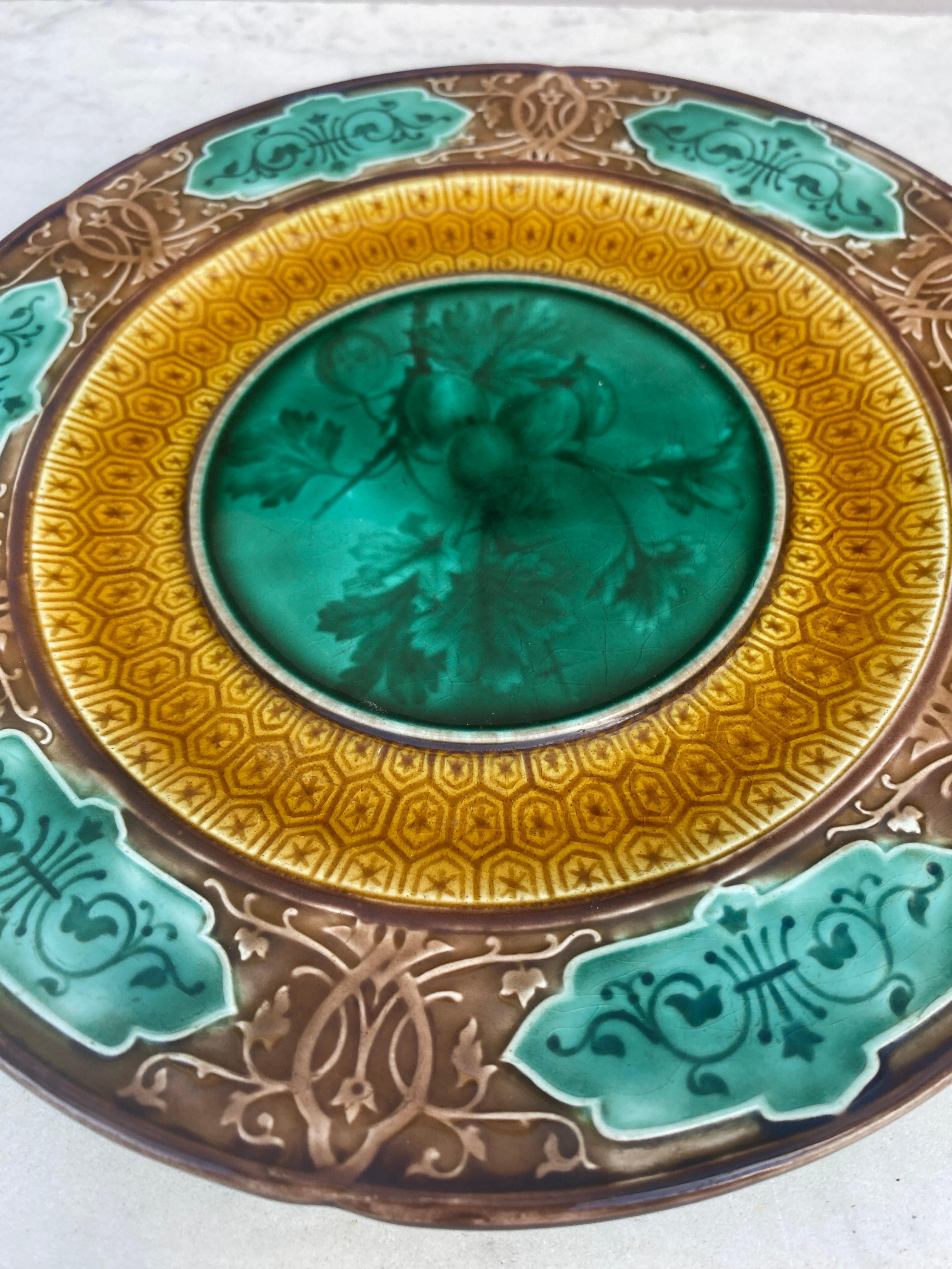 Assiette à groseilles en majolique signée Sarreguemines Majolica, vers 1870.
Motif géométrique sur la bordure.