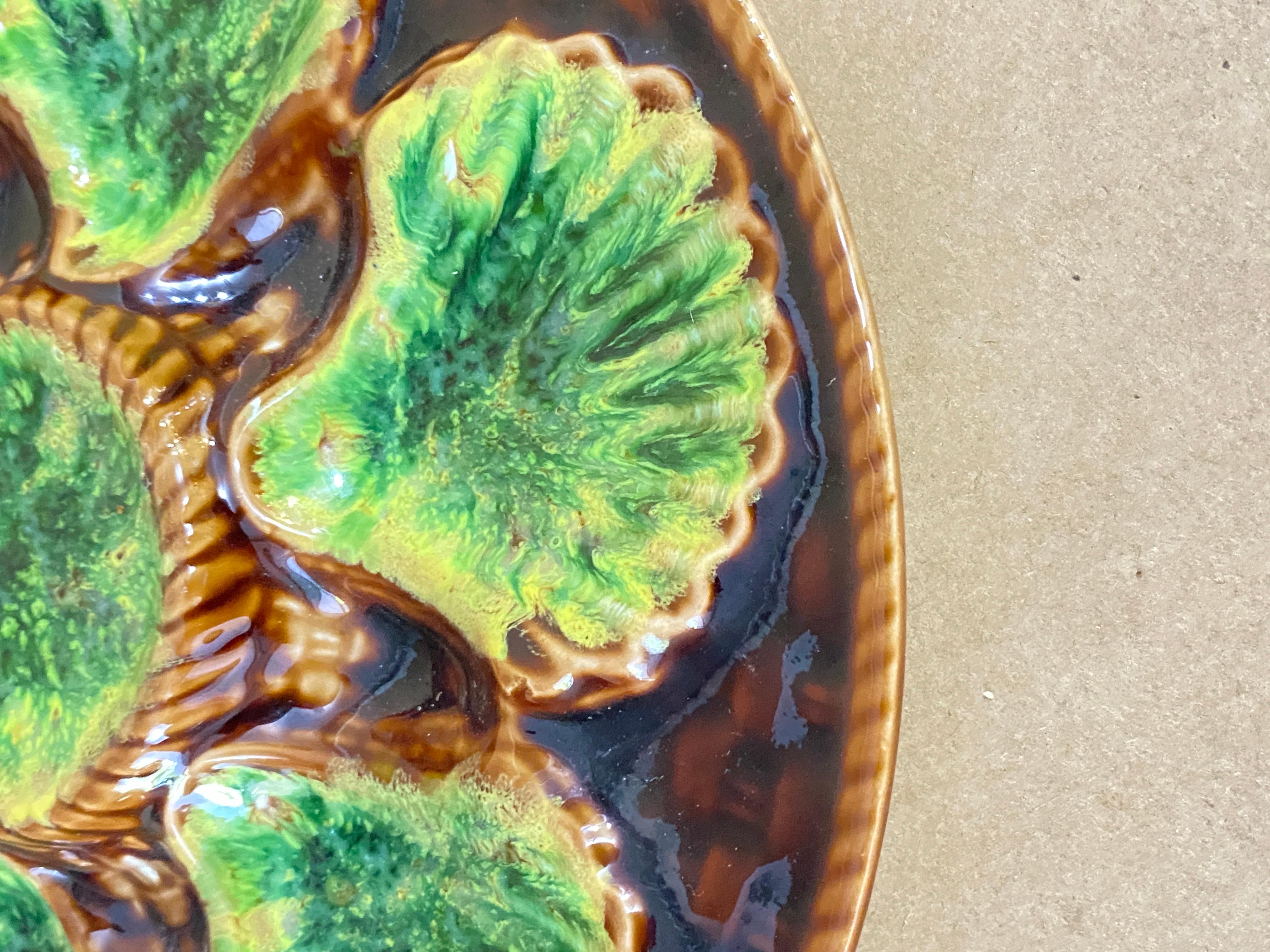Plateau à huîtres dans le style de la majolique, réalisé en céramique, en vert et brun.
France début du 20ème siècle.
