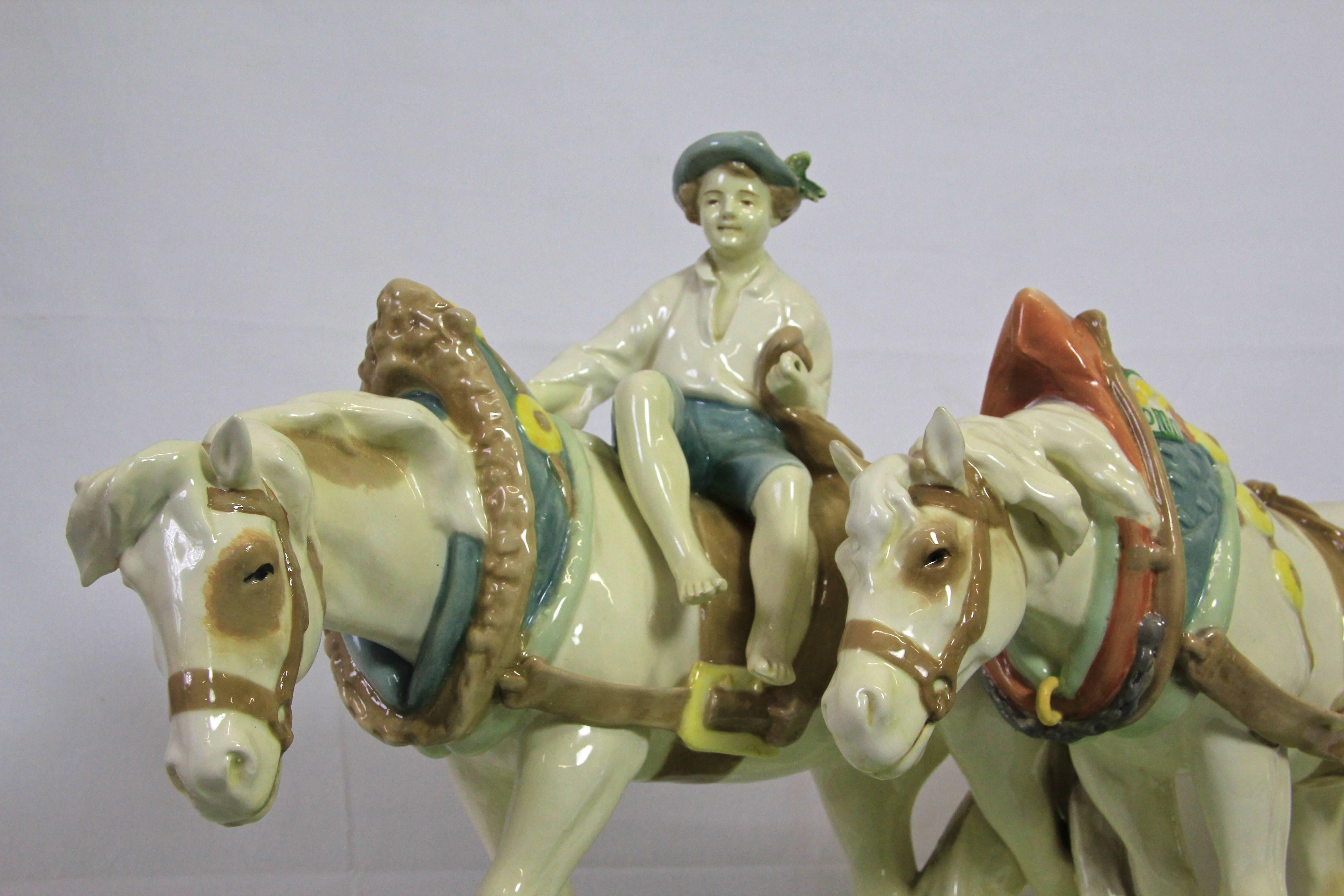 Fantastic Majolica horse sculpture by Royal Dux from the Art Nouveau period, around 1910. Made with great attention to details, this lovely large piece of majolica art depicting two festively decorated horses with a little farmer boy on it. Big