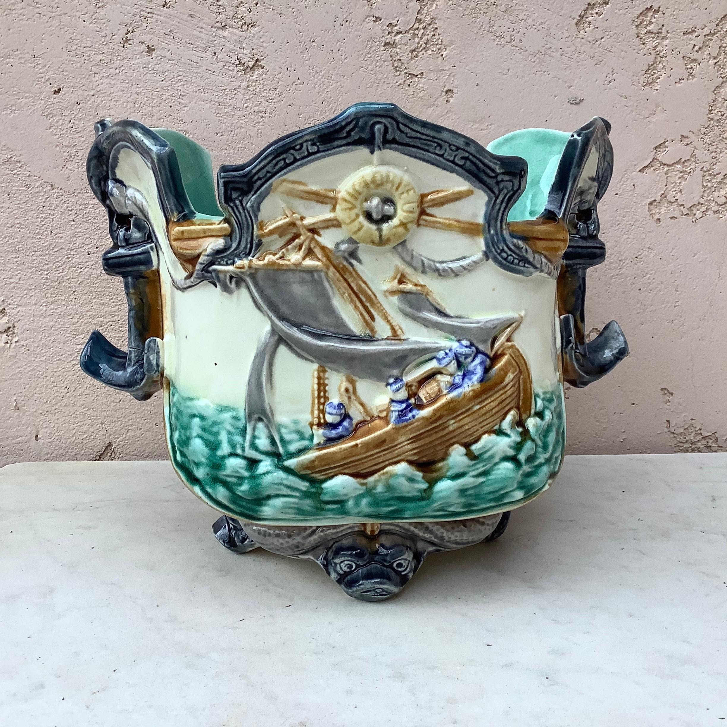 19th century Majolica nautical planter cachepot signed Onnaing, the feets are dolphins and the front is decorated with boats on the sea, the handles are anchors.