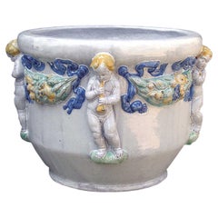 Macetero de mayólica Nymphenburg hecho y pintado a mano con relieve de querubines