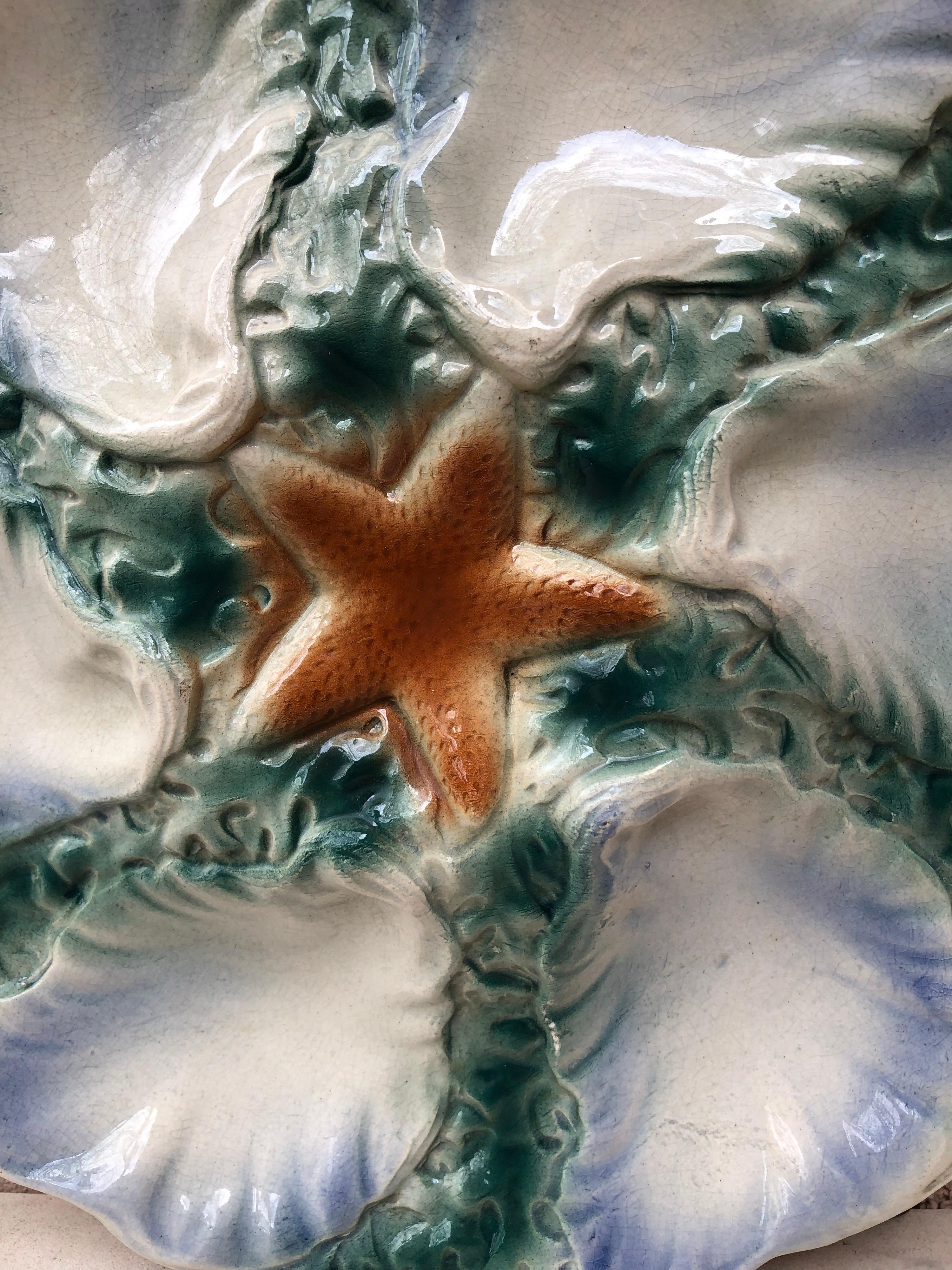 Lovely Majolica plate with blue starfish with six wells blue and white surrounded by green seaweeds signed Digoin (East of France), circa 1910.