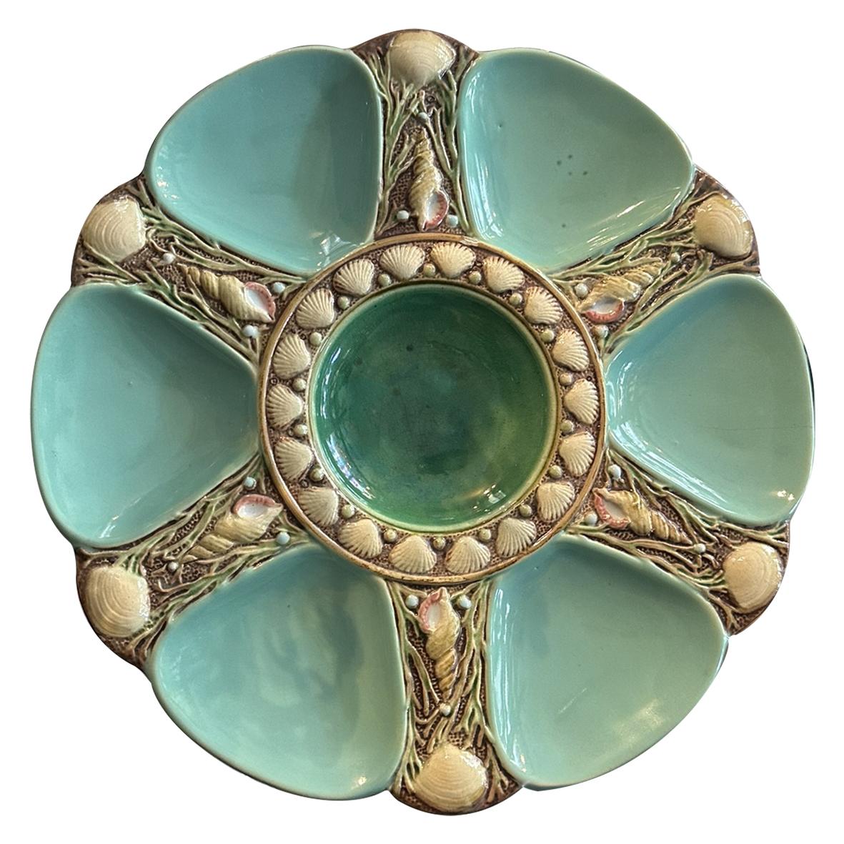 Questi piatti da ostrica in maiolica Minton sono stati prodotti in diversi colori. Delicato colore turchese con sfumature verdi iridescenti al centro del piatto. Decorato con raffinate conchiglie, perfetto per evocare un'atmosfera marina. Su ogni