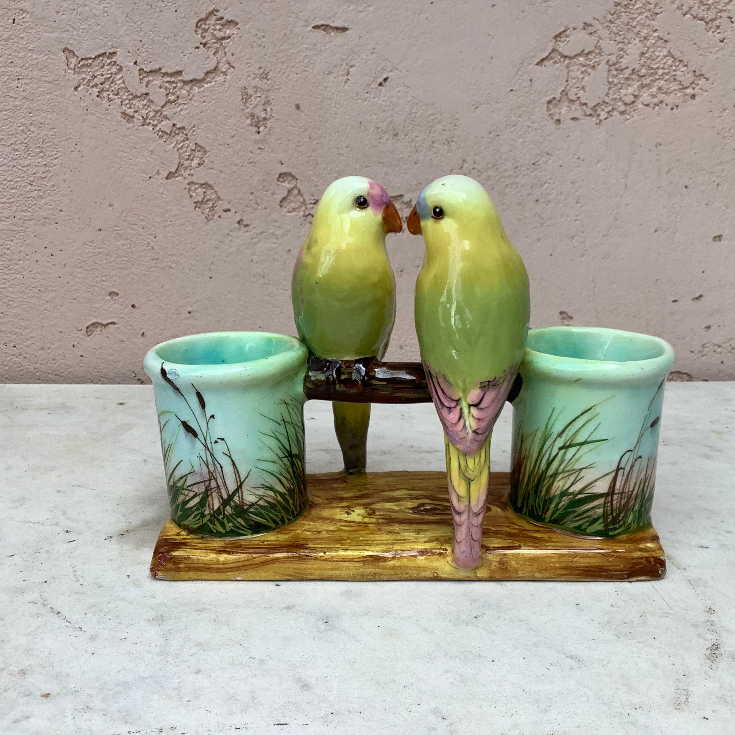 Colorful Majolica double vase with two parrots, the vase are decorated with painted pink flowers signed Delphin Massier, circa 1890.
 