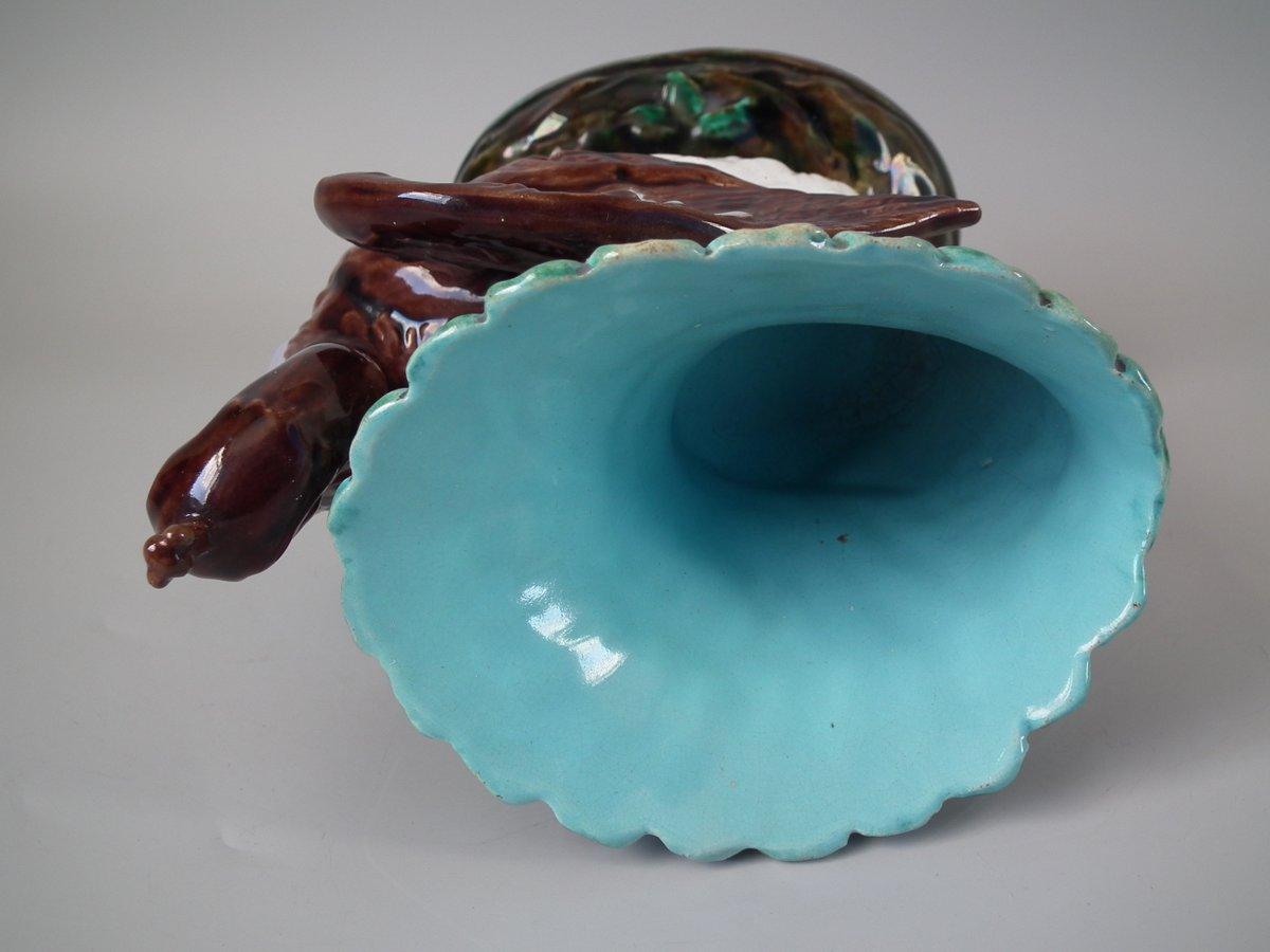Majolica vase which features a peacock. Coloration: brown, green, turquoise, are predominant.