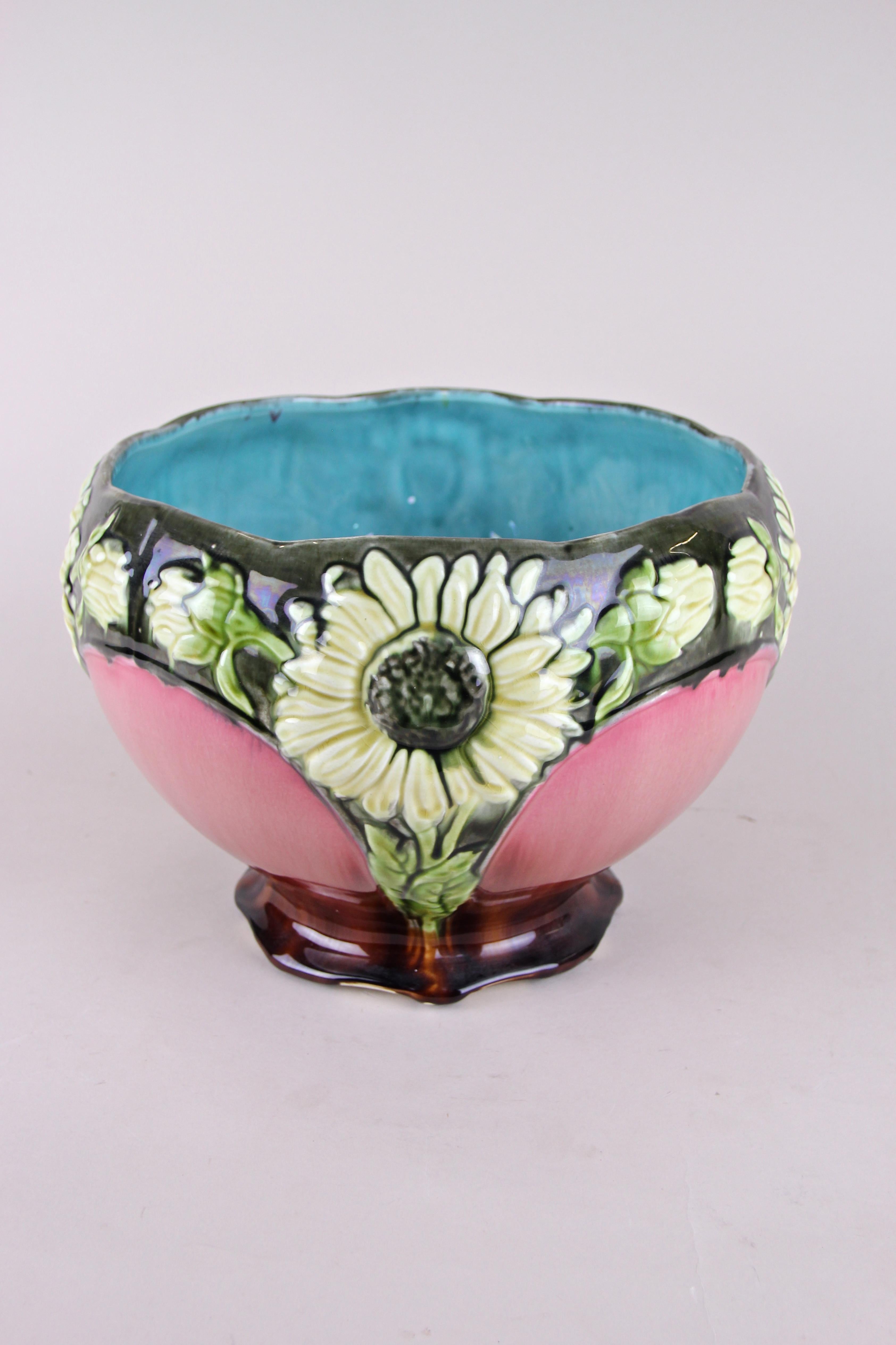 Beau grand cache-pot ou jardinière en majolique de la période Art Nouveau en France, vers 1910. Fabriqué par la célèbre manufacture Orchies, ce cache-pot présente un grand motif floral avec quatre grands tournesols divisés par des éléments de