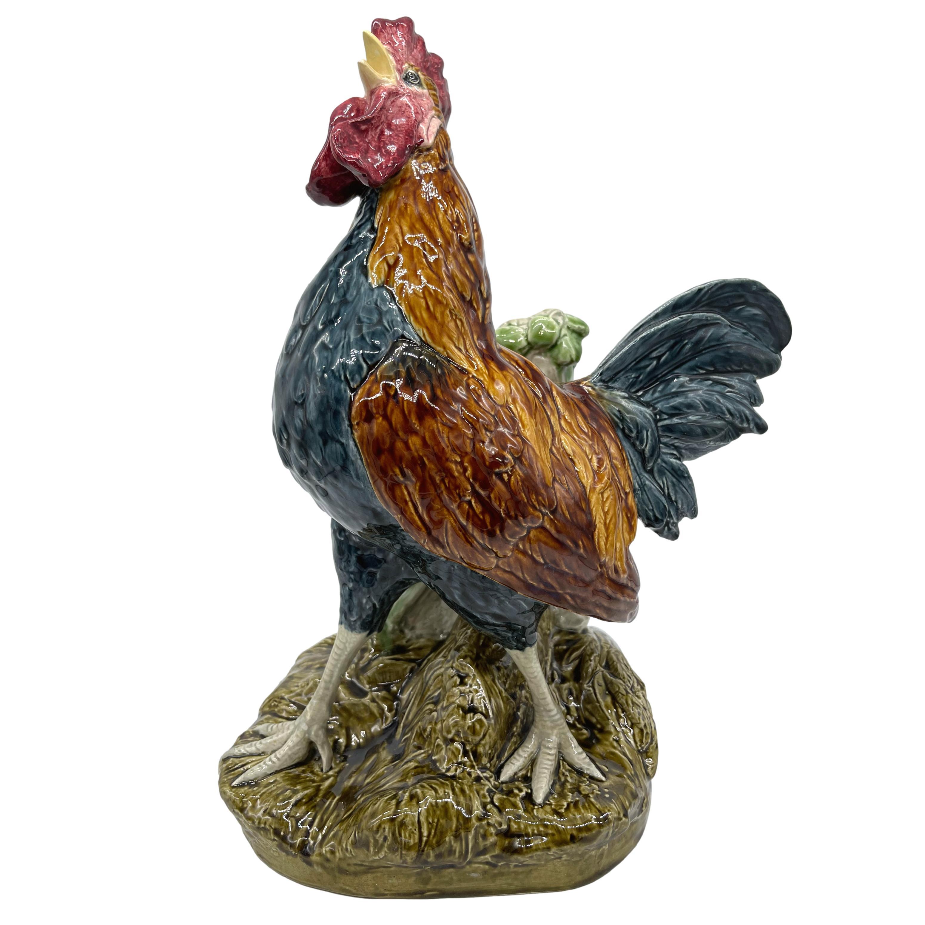 Majolica Cockerel Spill Vase by Choisy-le-Roi, naturalistically modeled and glazed as a crowing rooster on a molded barnyard base, the rectangular vase formed by simulated stacked stones with trailing ivy and pink glazed cornflowers, with impressed