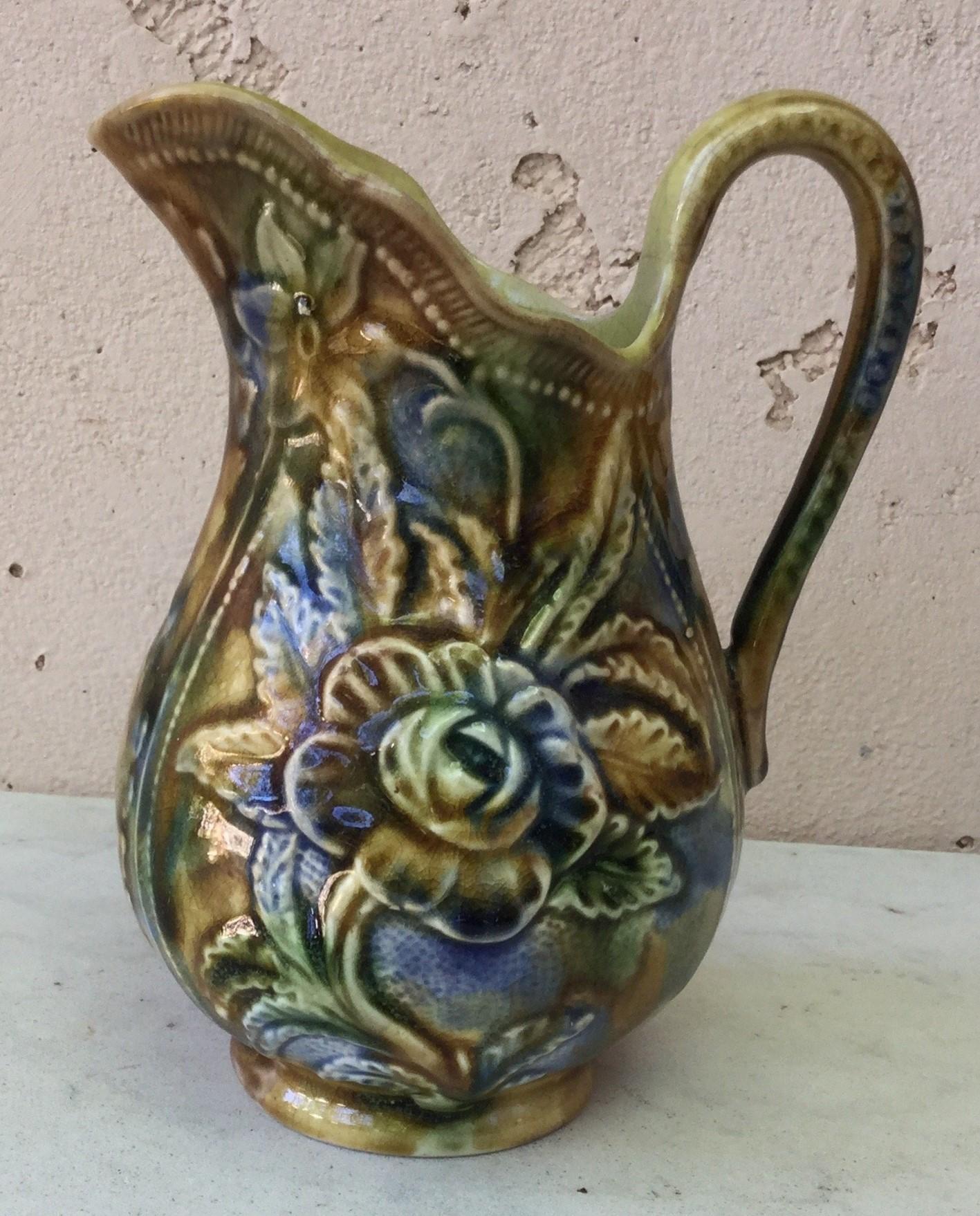Small Majolica pitcher mottled blue brown yellow and green circa 1890 decorated with rose and others flowers.