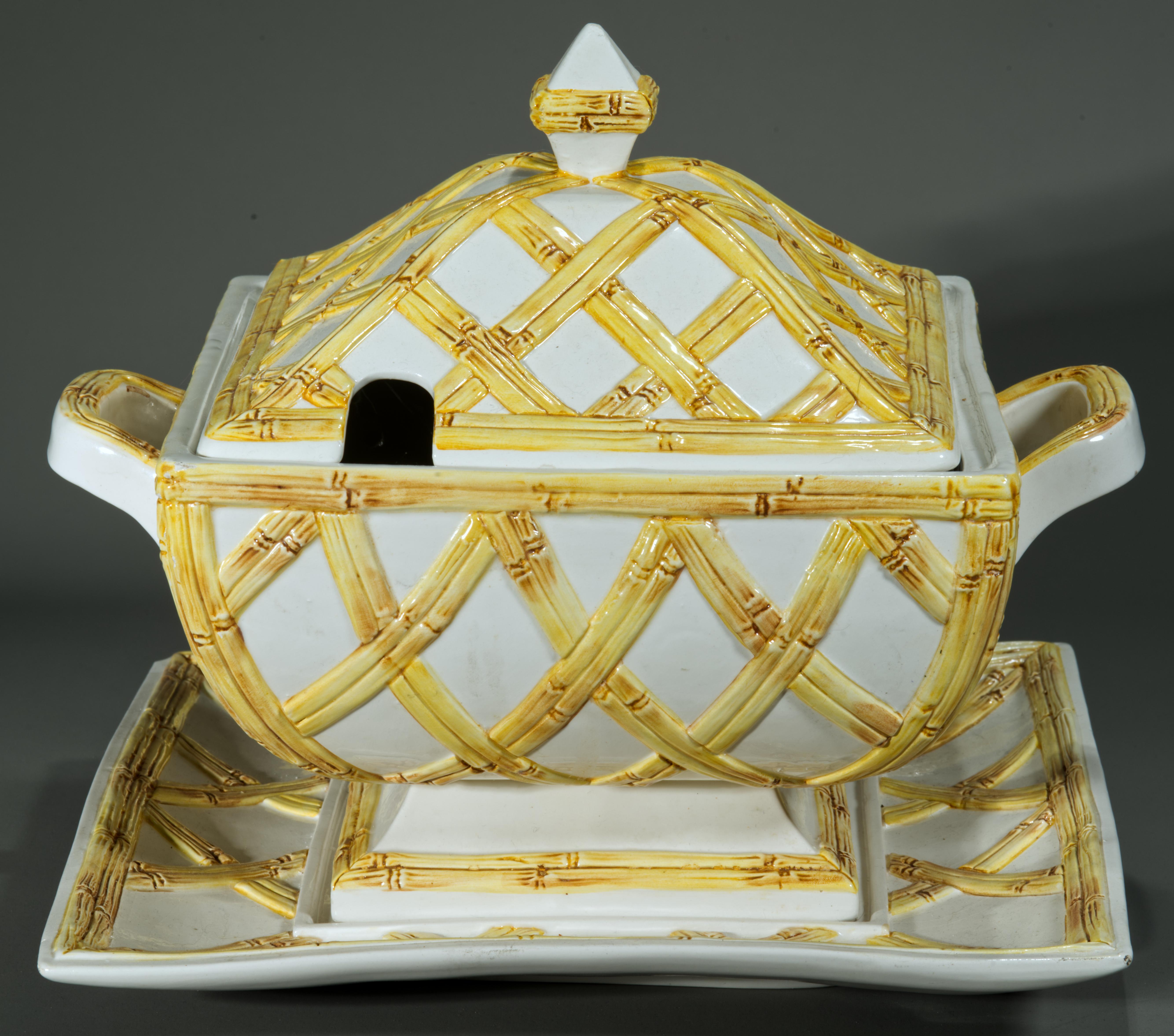 L'ensemble de service impressionnant composé d'une soupière avec couvercle et d'un sous-plat présente un corps en céramique ou en porcelaine avec un décor en faux bambou, formant une forte garniture géométrique dans le style chinois Chippendale. Les