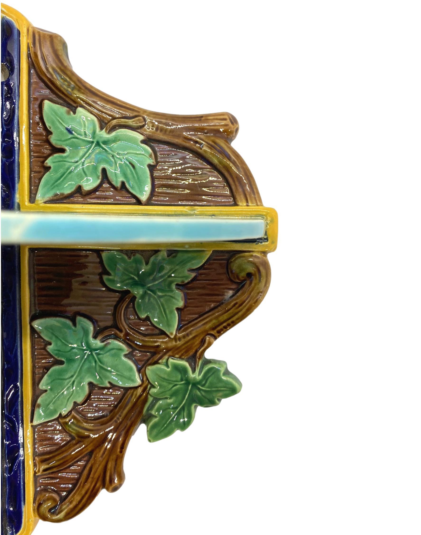 Majolica small-form corner shelf by T.C. Brown-Westhead, Moore & Co. Naturalistically molded as green-glazed ivy leaves, molded twigs on a bark ground, centrally fitted with a turquoise-glazed shelf, English, ca. 1877. 
For thirty years, we have