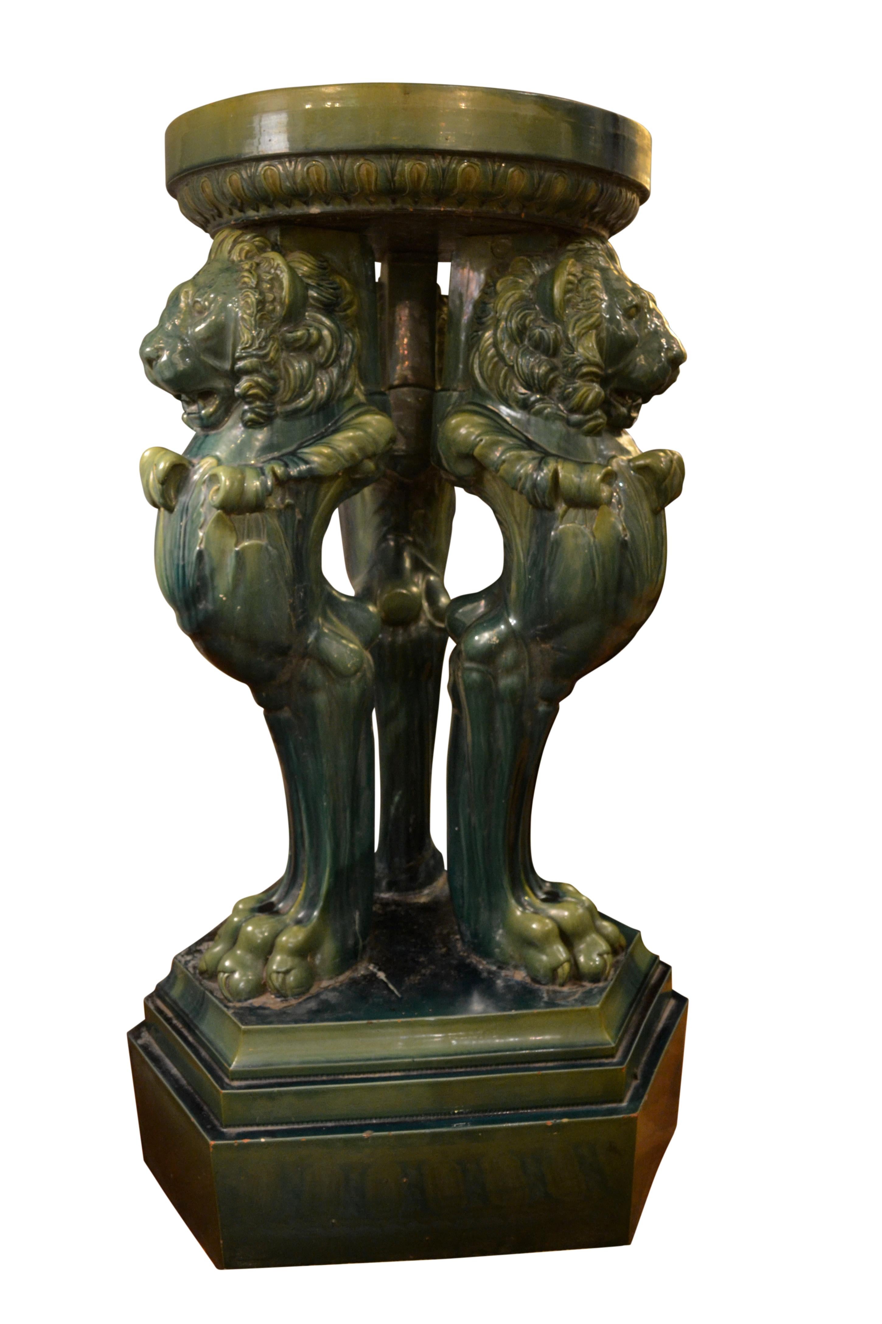 A very large Majolica Grand Tour pedestal having dark green glazing; the circular top (detachable) supported by  Trapezophorus  tripod base after the Roman. original found in Hadrian's Villa. The whole is set on  sit on a stepped triangular base.