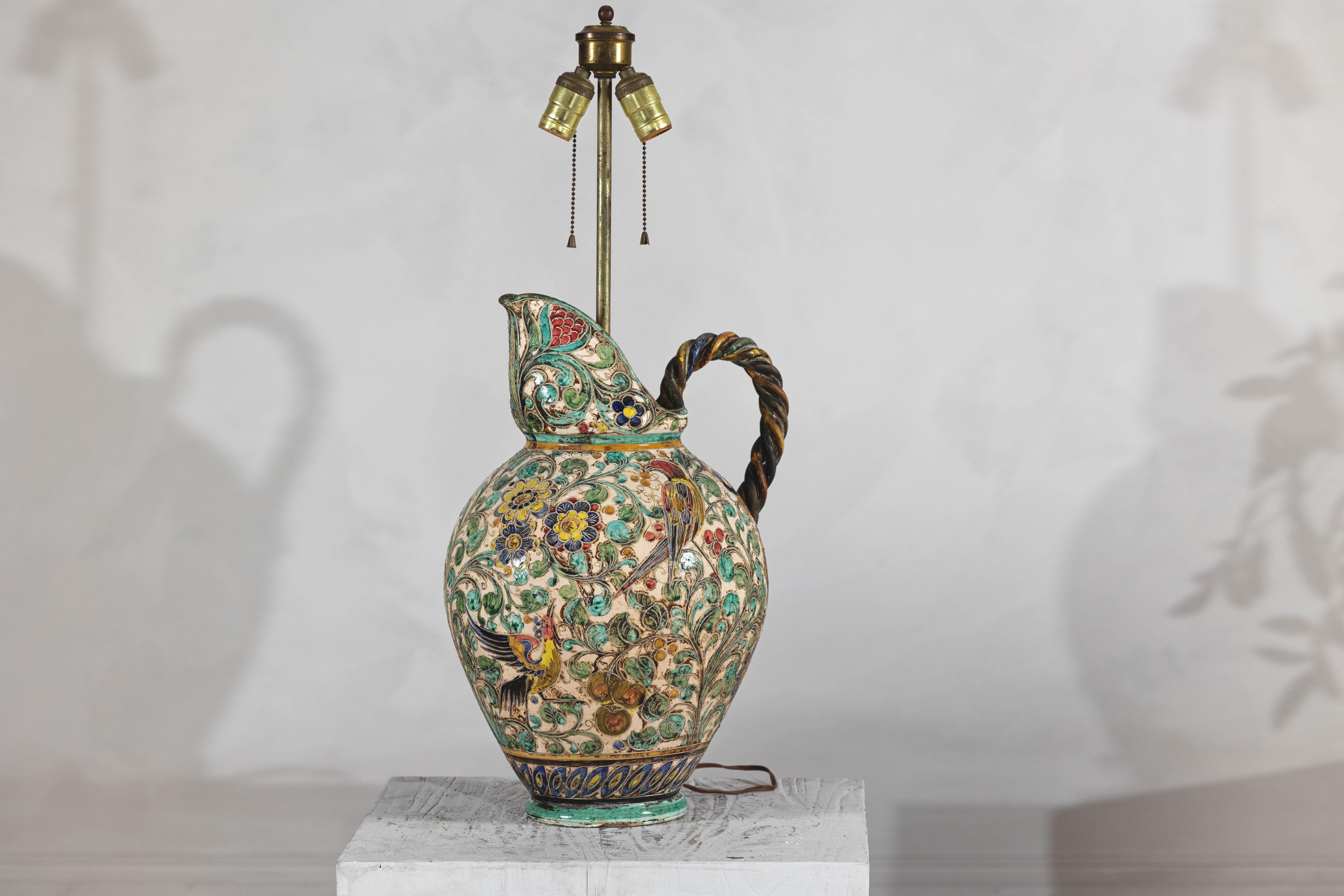 A Majolica inspired ceramic jug table lamp, wired for the USA. Infuse your space with vibrant color and timeless artistry with this mid-century Majolica-style table lamp. Crafted from ceramic, this lamp features an intricate raised design of