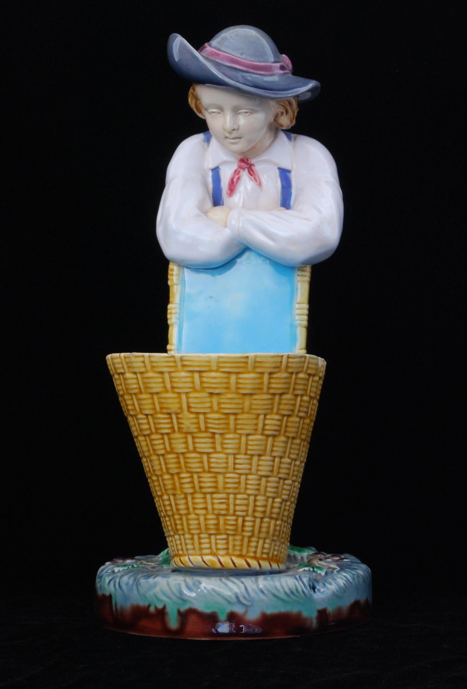 A brightly coloured majolica sweetmeat dish in the form of a bucolic young man leaning on a basket.

Minton majolica is a type of ceramic ware that was produced by the Minton pottery in the 19th century. It was created in response to the growing
