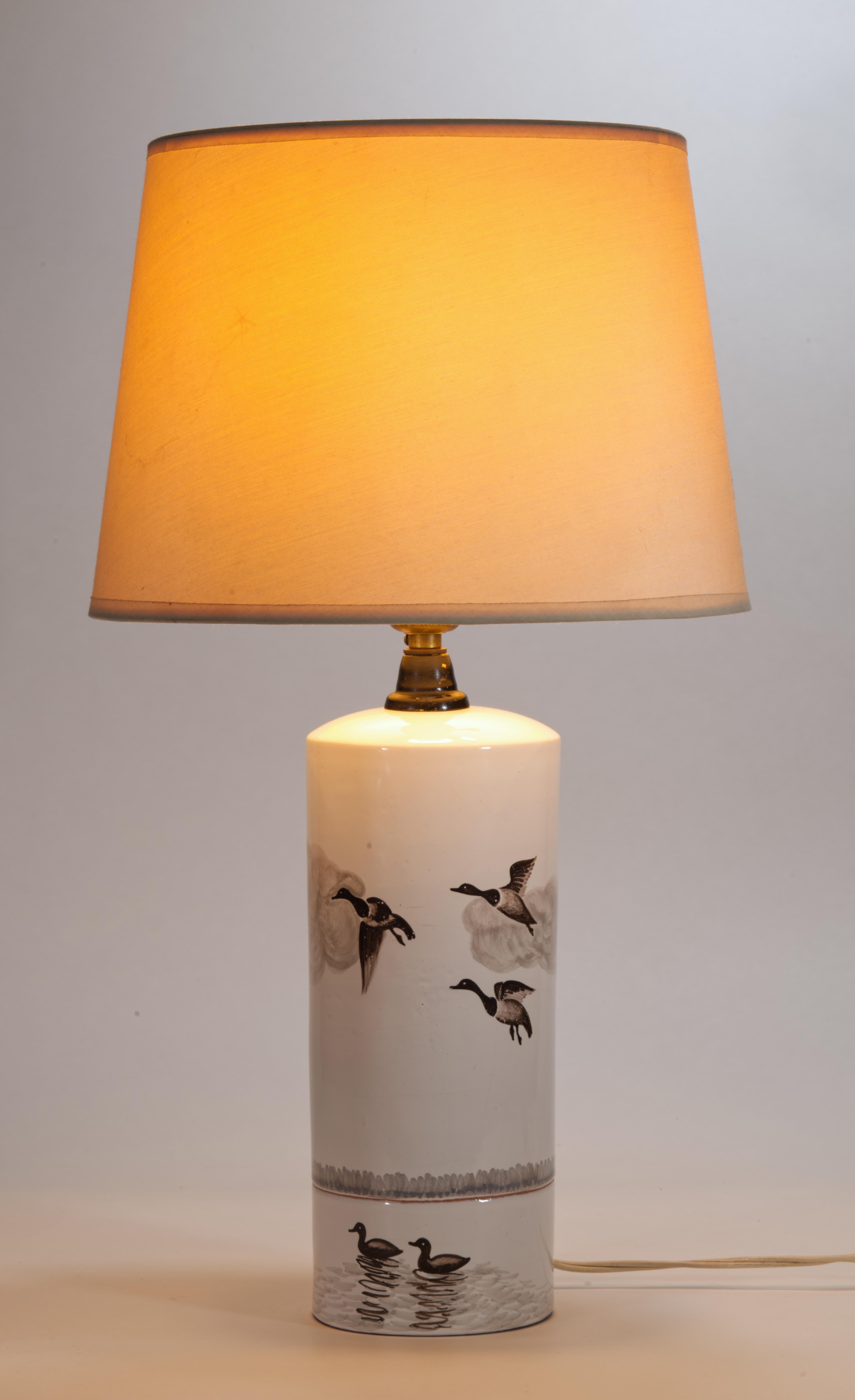Vintage majolica table lamp features hand-painted country landscape with flying ducks or geese, evocative of a hunting scenes in traditional English paintings. Minimal white background allows the lamp to look crisp and fresh while being fully