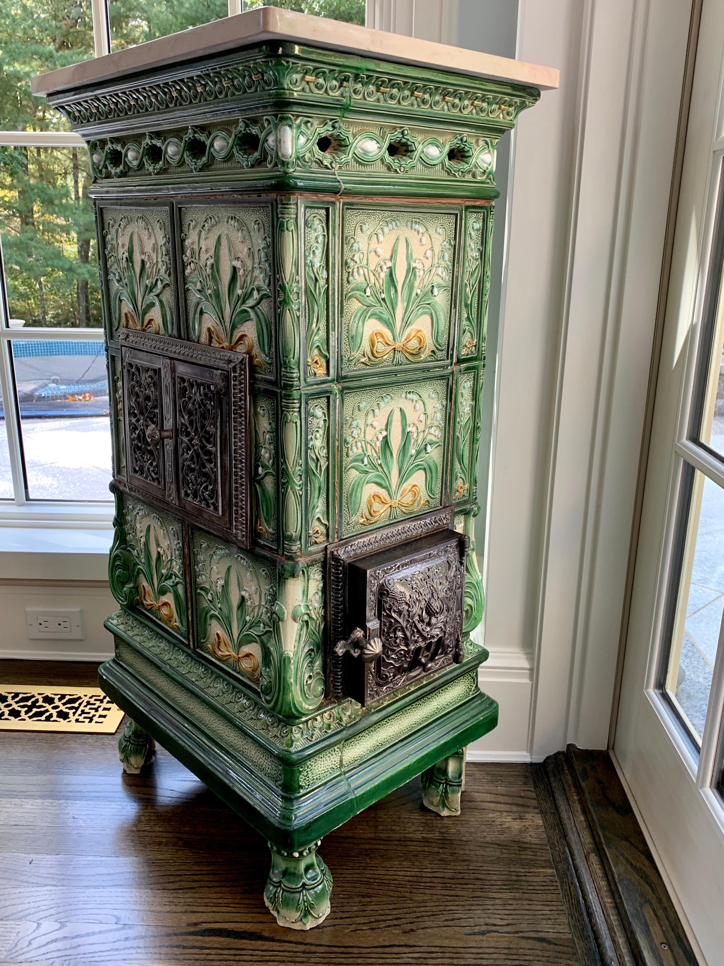 This beautiful French Majolica tile stove is from circa 1910- 1920. The Tiles depict Lillies of The Valley in relief.