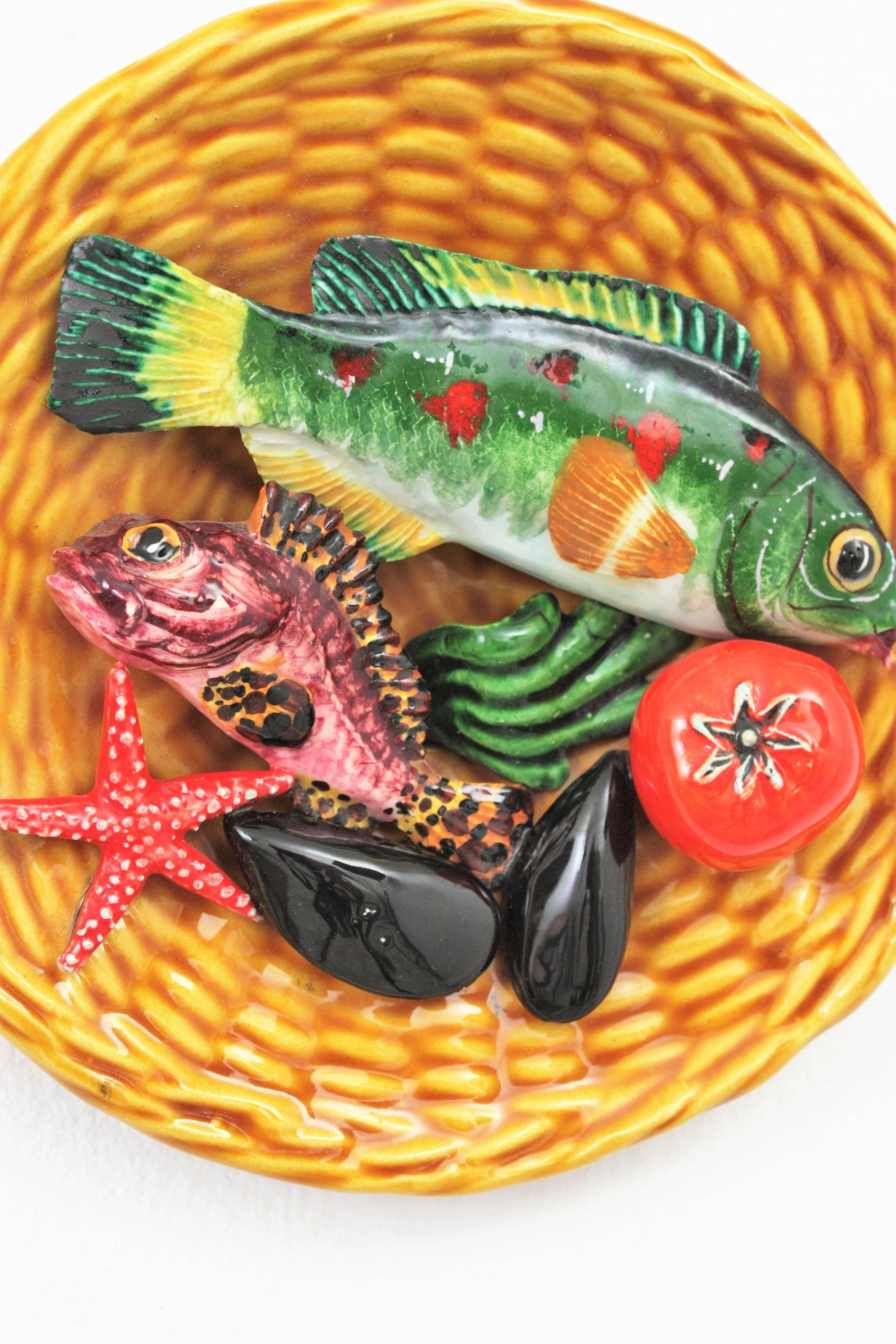 Eye-catching glazed ceramic trompe l'oeil seafood basket wall plate manufactured by Atelier Lamarche Monaco.
This piece would be a nice addition as wall decoration in a kitchen or dining room. Lovely to create a wall composition with other trompe