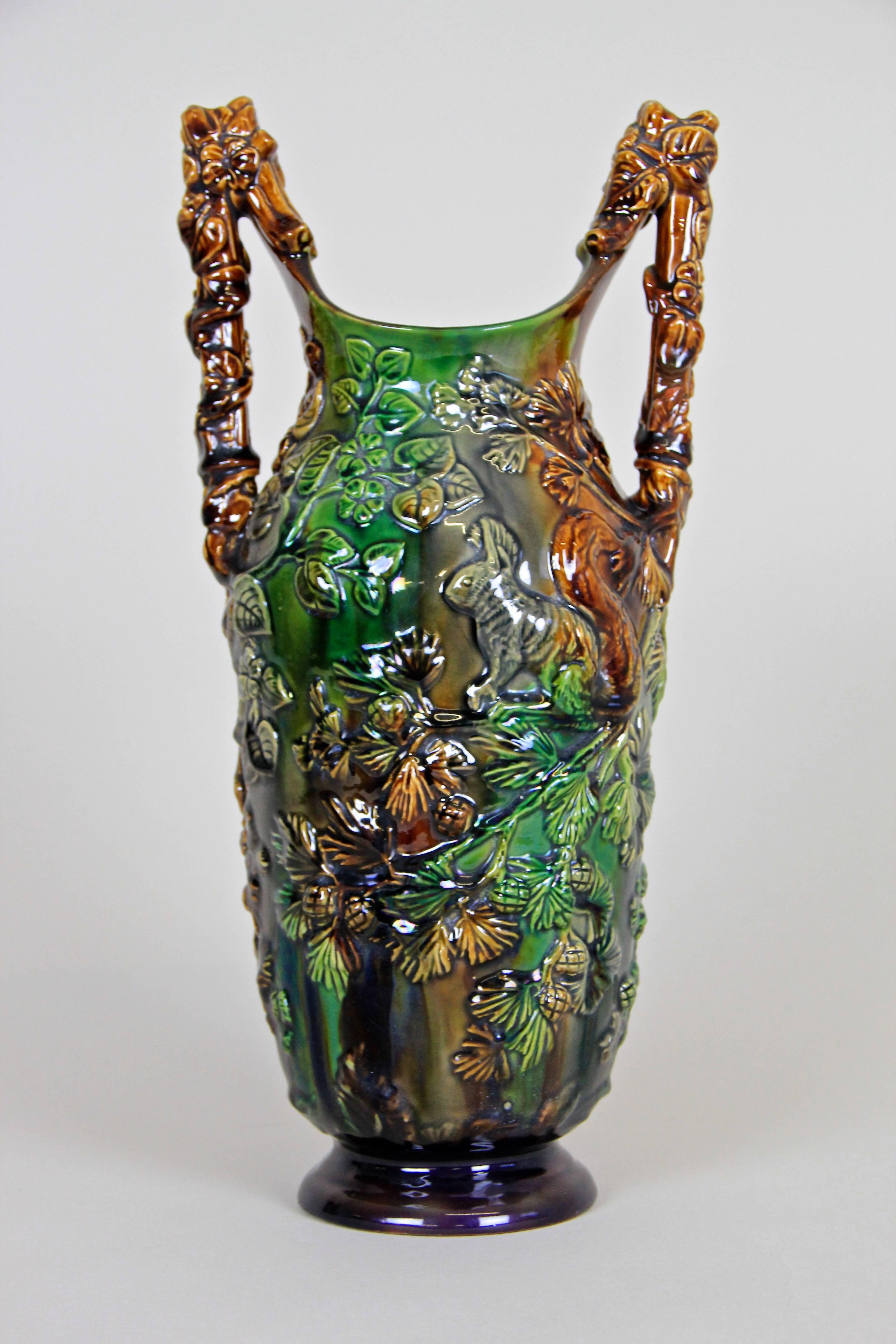 Unique Majolica vase from the famous workshops of Eichwald/ Bohemia circa 1900. This unusual shaped majolica vase impresses with an absolute extravagant embossed forest design showing different kind of tree branches, tendrils and three squirrels.