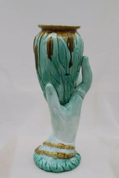 Majolica vase of a woman's hand holding bulrushes