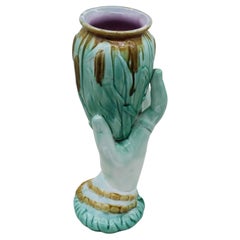 Majolica vase of a woman's hand holding bulrushes