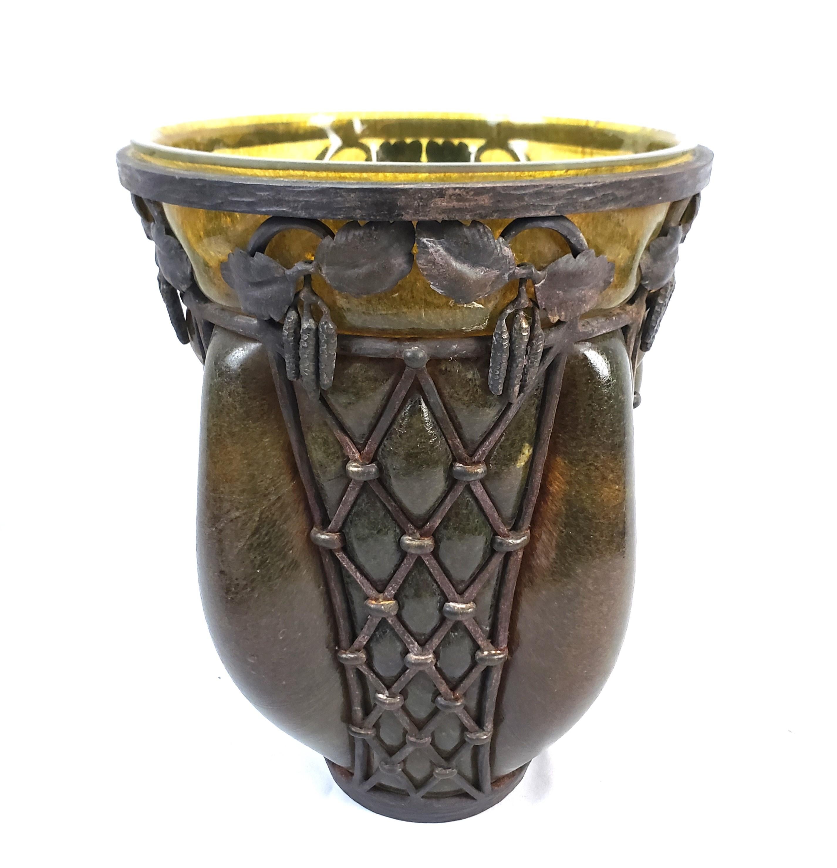 This large art glass vase was done by the renowned artists Louis Marjorelle and Daum Nancy of France and dates to approximately 1920 and done in the signature Art Deco style. The vase is done with a very thick dark amber art glass blown and formed