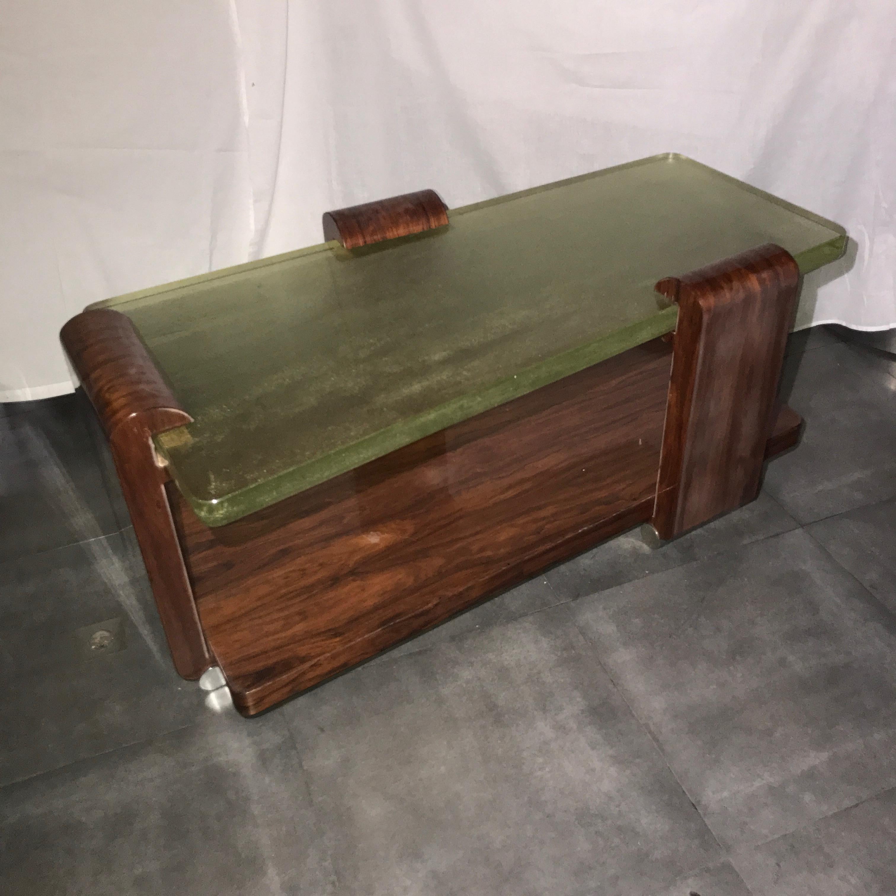 A rosewood low table with a Saint Gobain glass top designed by Maison Majorelle in France circa 1925. 
A modernist model of high quality, probably created for a private order. The glass slab has a trapezoidal shape and a thickness of 44 mm/1.57