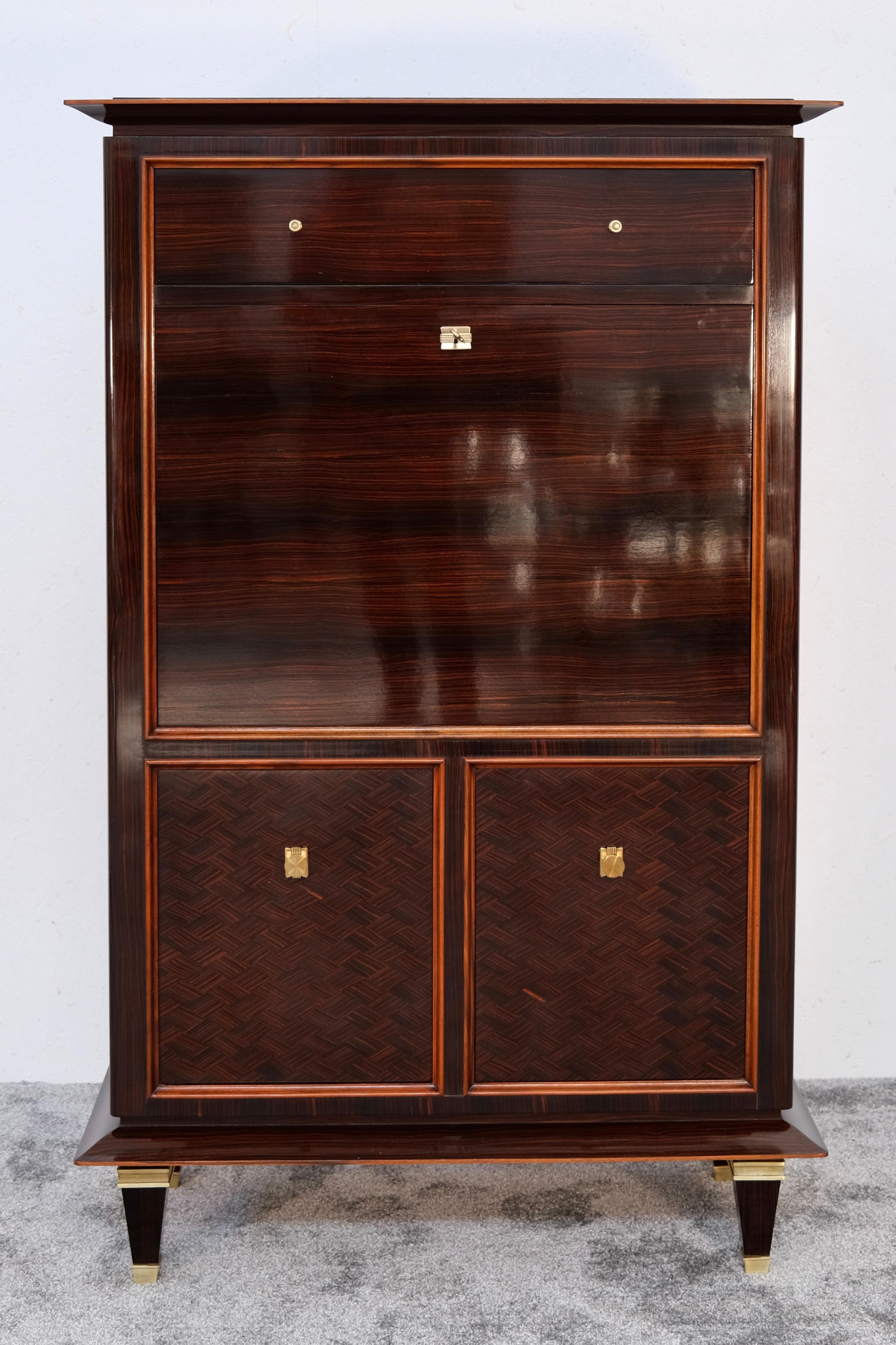 This striking Art Deco secretary desk from the 1930s showcases masterful craftsmanship paired with the expressive beauty of the finest materials. The high-gloss polished Macassar wood, with its distinctive dark striping, exudes graphic elegance and