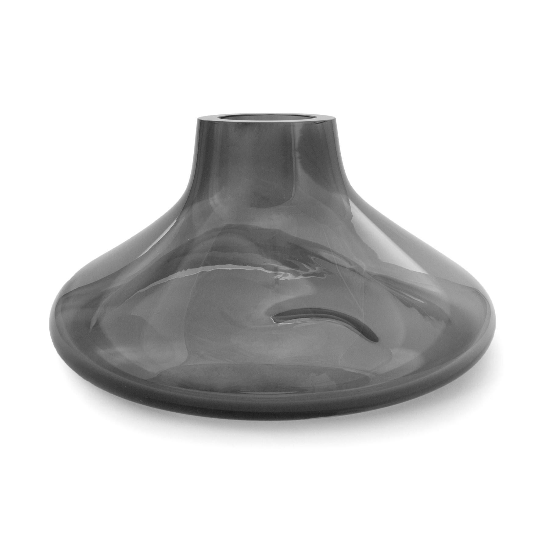Makemake Silver Smoke L Vase + Bowl by ELOA
Material: Glass
Dimensions: D40 x W40 x H25 cm
Also Available in different colours and dimensions.

Makemake is reminiscent of Jupiter‘s ring. The object was designed with a double functionality and