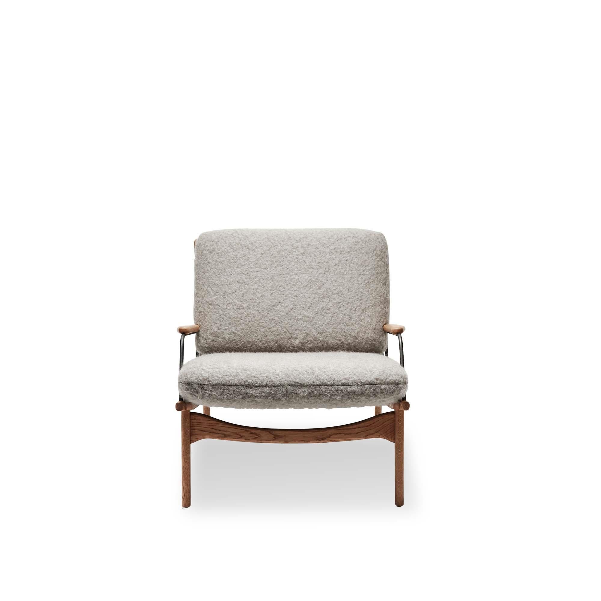 Fauteuil de fabricant par Lawson-Fenning. Le fauteuil Maker's Armchair est une chaise à structure en noyer ou en chêne massif, avec un harnais en cuir et des détails en laiton sur l'assise et le dossier. Les coussins d'assise et de dossier sont
