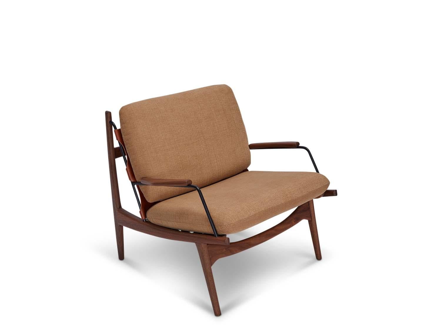Fauteuil de fabricant par Lawson-Fenning. Le fauteuil Maker's Armchair est une chaise à structure en noyer ou en chêne massif, avec un harnais en cuir et des détails en laiton sur l'assise et le dossier. Les coussins d'assise et de dossier sont