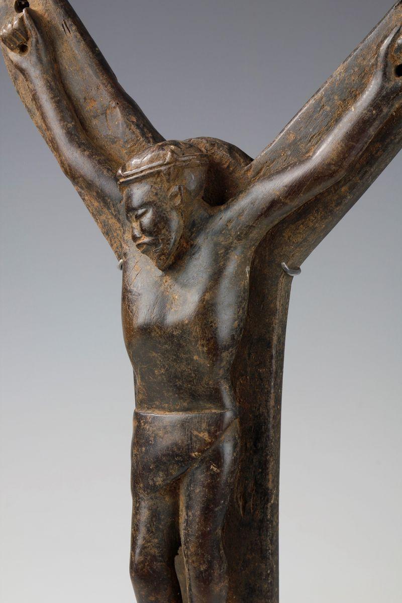 This African Jesus exhibits finely carved features. Depicting a black Jesus with his head leaning to one side, wearing a crown of thorns and with his arms outstretched on the cross. Carved from one piece of a heavy dark wood with a deep worn surface