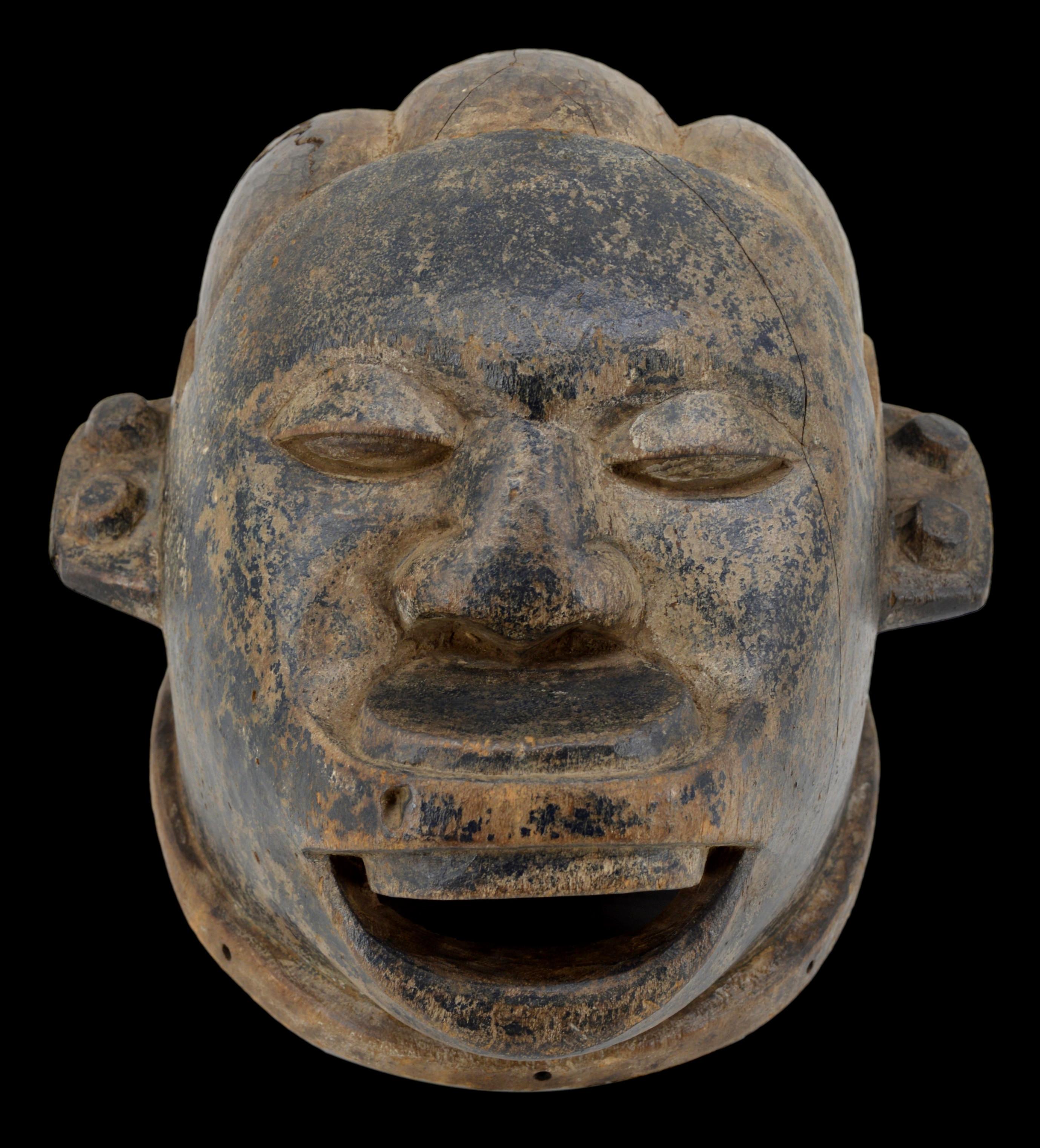 Masque-casque Makondé , Tanzanie, Afrique, début du 20e siècle. Visage de femme avec un bouchon à lèvres. La jeune femme représentée porte des boucles d'oreilles. Sa coiffure présente trois grandes tresses sculptées à la main. Bois sculpté. Largeur