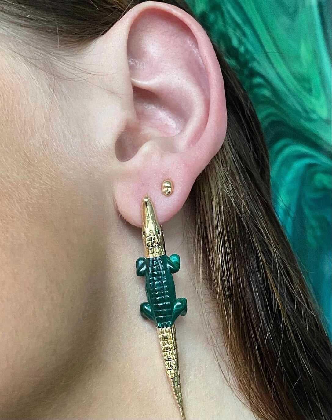 Intricately carved and hand-crafted to replicate an alligator’s body in miniature. These earrings are designed in 18k yellow gold with the alligator’s mouth acting as the earrings’ closing bite mechanism to snap onto the ear. The body of the