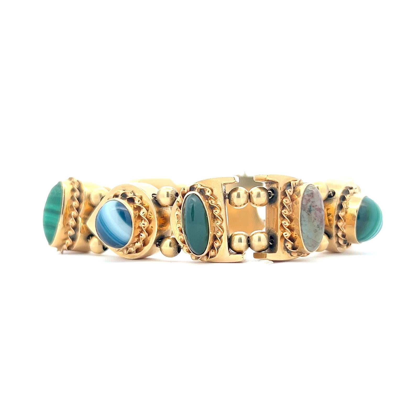 Original vintage slide bracelet crafted in 14 karat yellow gold. The charms feature malachite, amethyst, garnet, and citirine gemstones. The braelet measures 6.5 inches in length, box clasp with safety chain. 