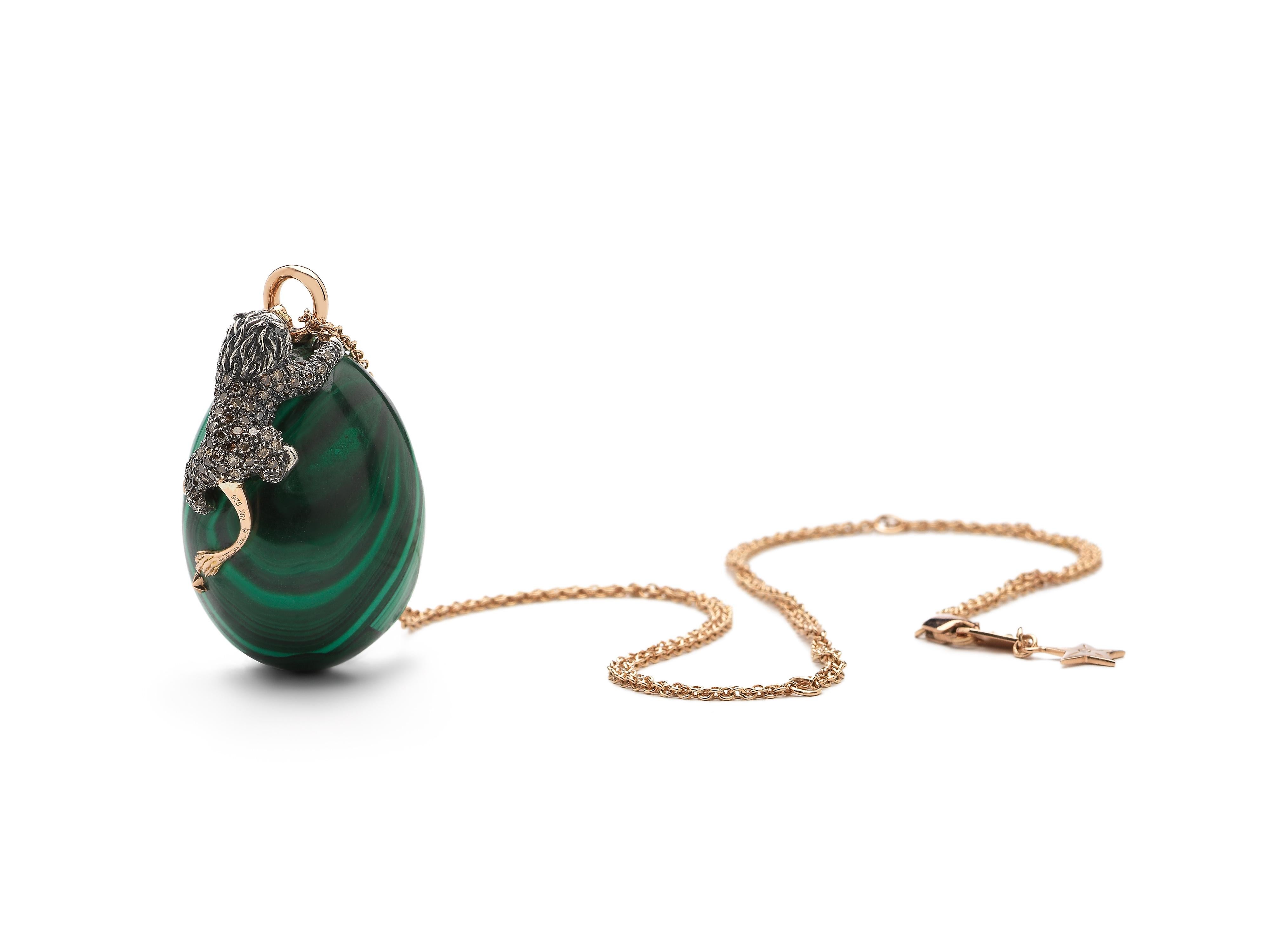A mesmerizing piece of malachite, a stone prized for protecting and absorbing negative energy, is the focal point of this pendant necklace. The stone is embellished with 18k rose gold stars, and a lion crafted in 18k rose gold and sterling silver.