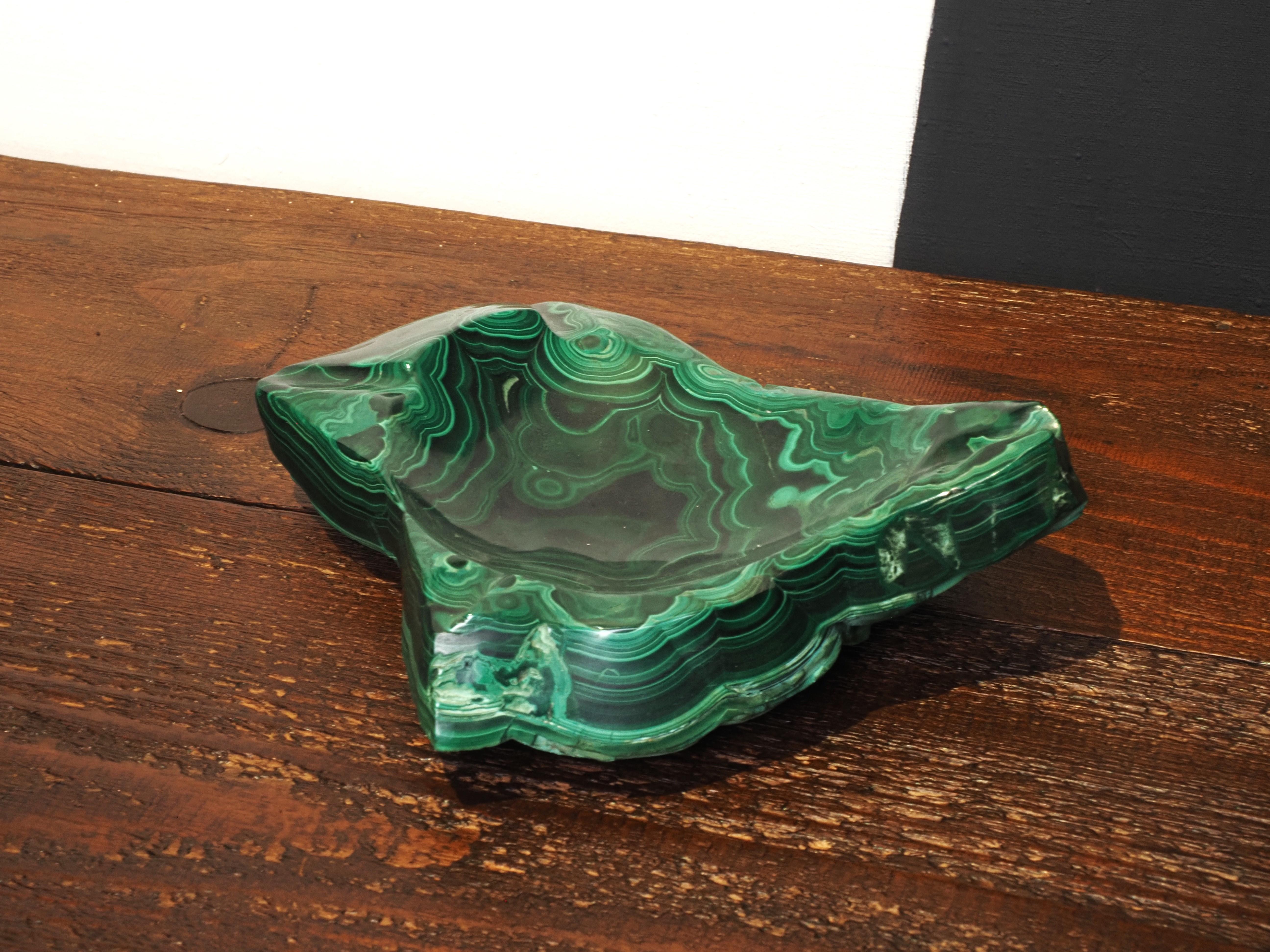 A vintage african malachite ashtray from the 1970s is a small, elegant dish crafted from malachite stone in Rep of Congo during the 1970s, typically featuring rich green hues and a sleek design characteristic of the era.