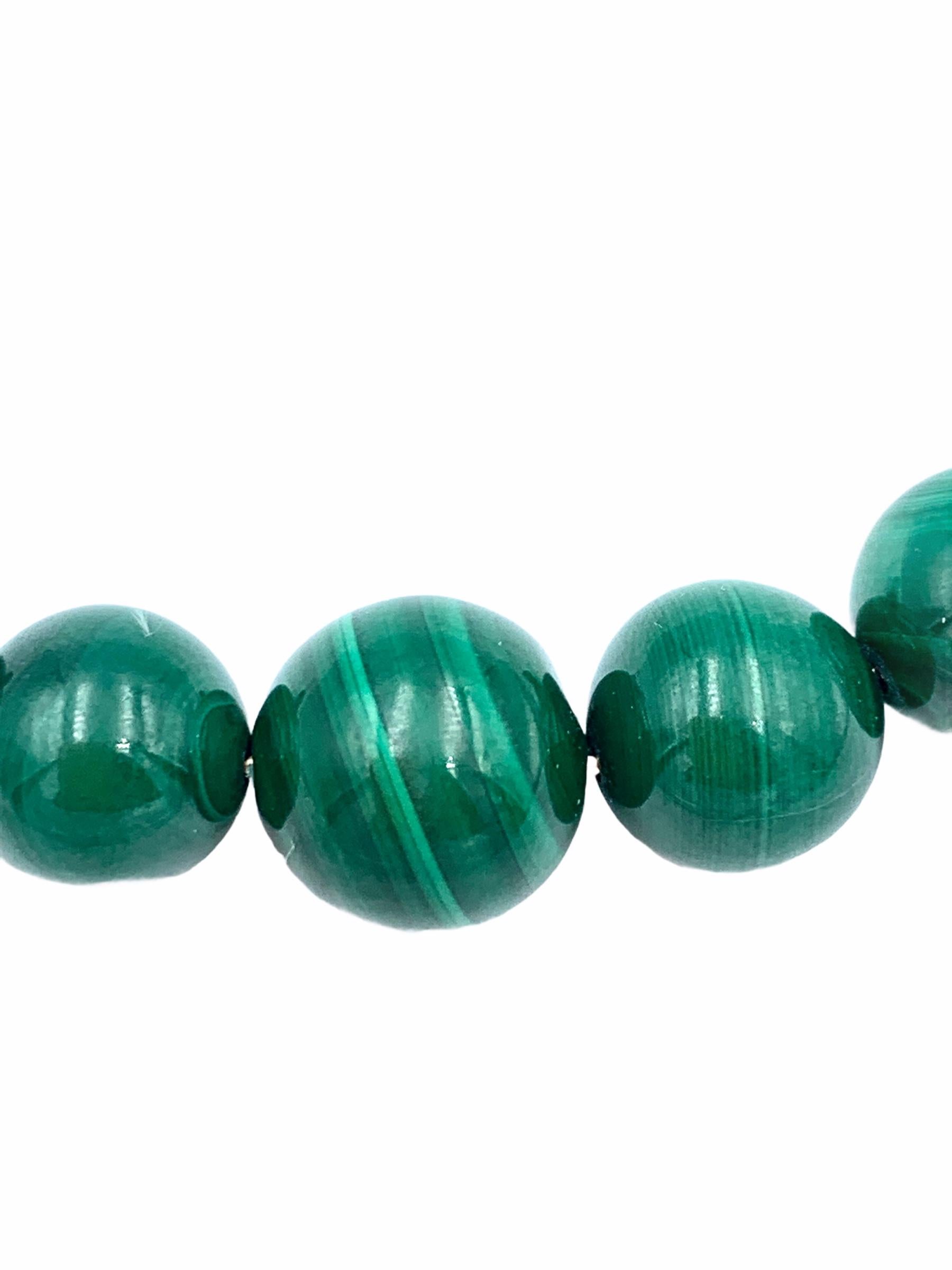 Die aus 9-karätigem Gelbgold handgefertigten Malachit-Perlen sind mit einem massiven Golddraht aufgefädelt und an einer zarten 1,7-mm-Kabelkette befestigt. Der schöne grüne Wirbel der mittleren Perle ist 12 mm groß, die beiden folgenden 10 mm, die