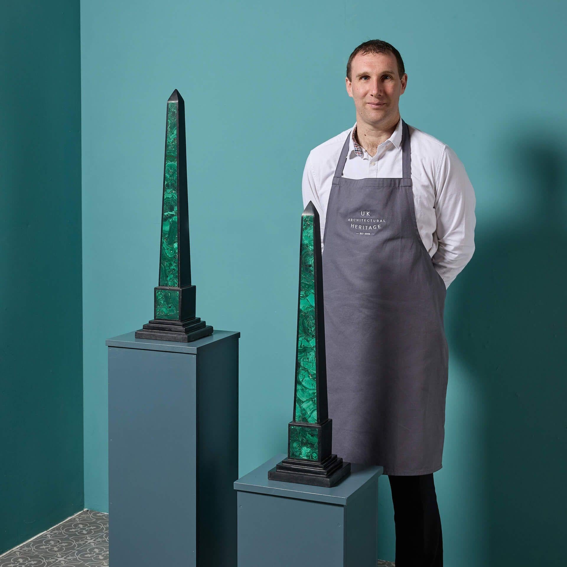 A pair of large reclaimed malachite and black marble obelisks. This pair of matching neoclassical style obelisks are suitable for any interior, making a striking statement either side of a mantlepiece or positioned on pedestals between a