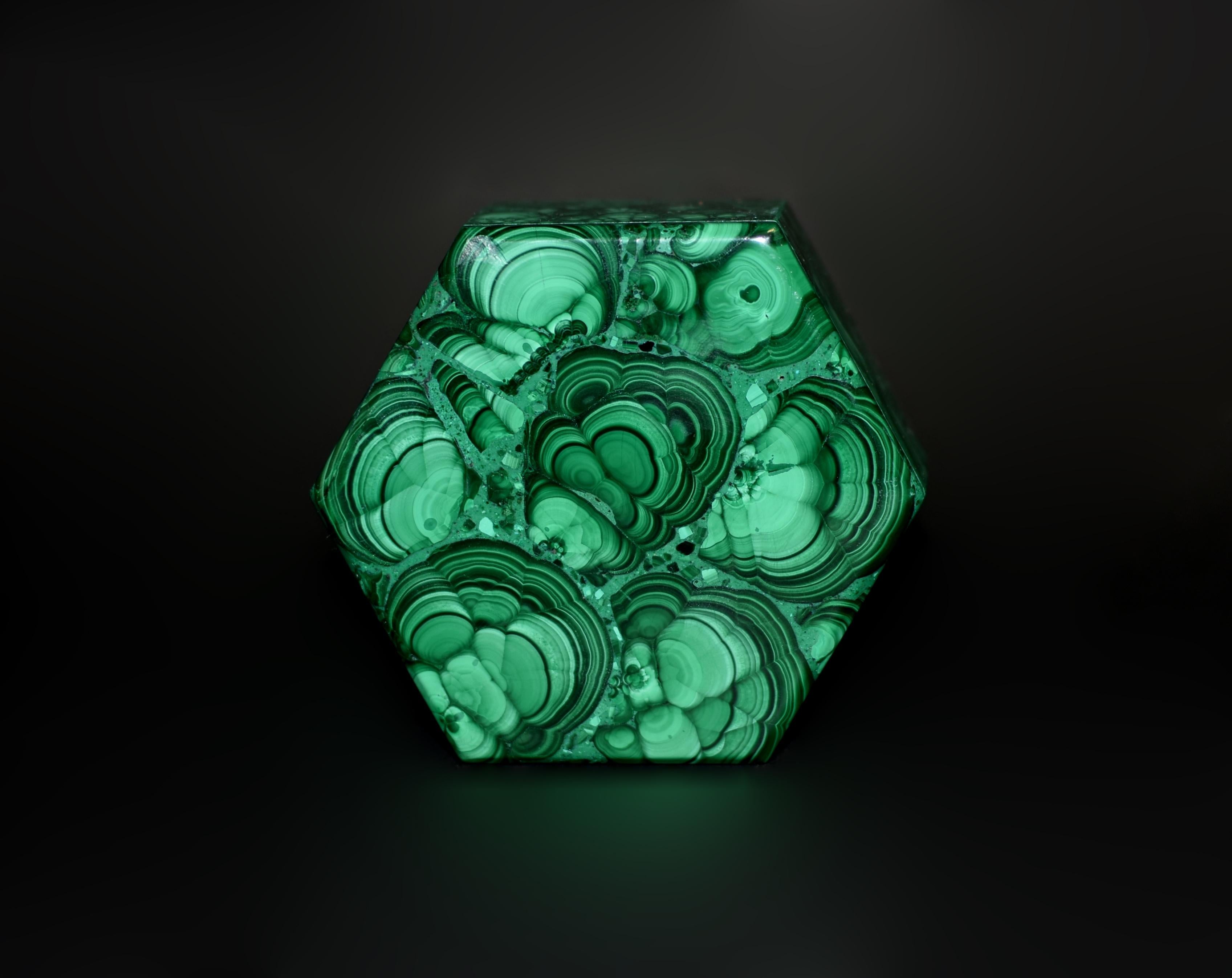 This extraordinary fine-grade malachite hexagonal box showcases the coveted turkey tail pattern, a rare and highly prized formation within the stone. Malachite, renowned for its captivating spectrum of green hues, is most prized when it displays
