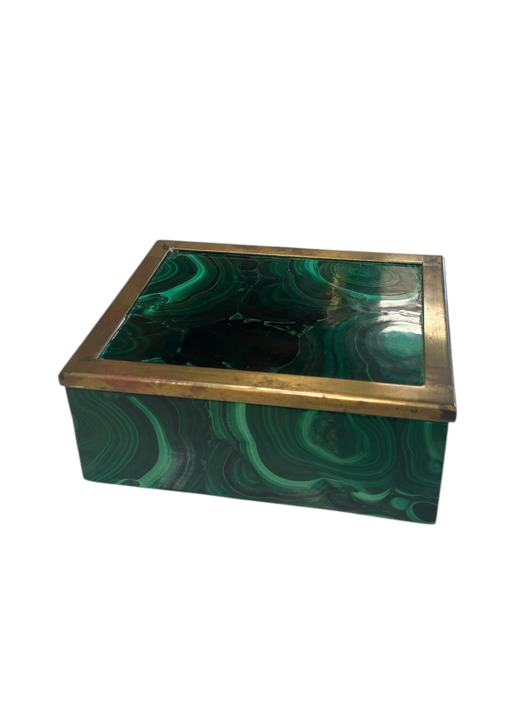 Beautiful and luxurious malachite decorative box from the 1970s, showcasing vibrant swirling green tones and a striking brass-trimmed lid. Perfect for storing small items or serving as a sculptural accent on a desk, console, or vanity. A refined