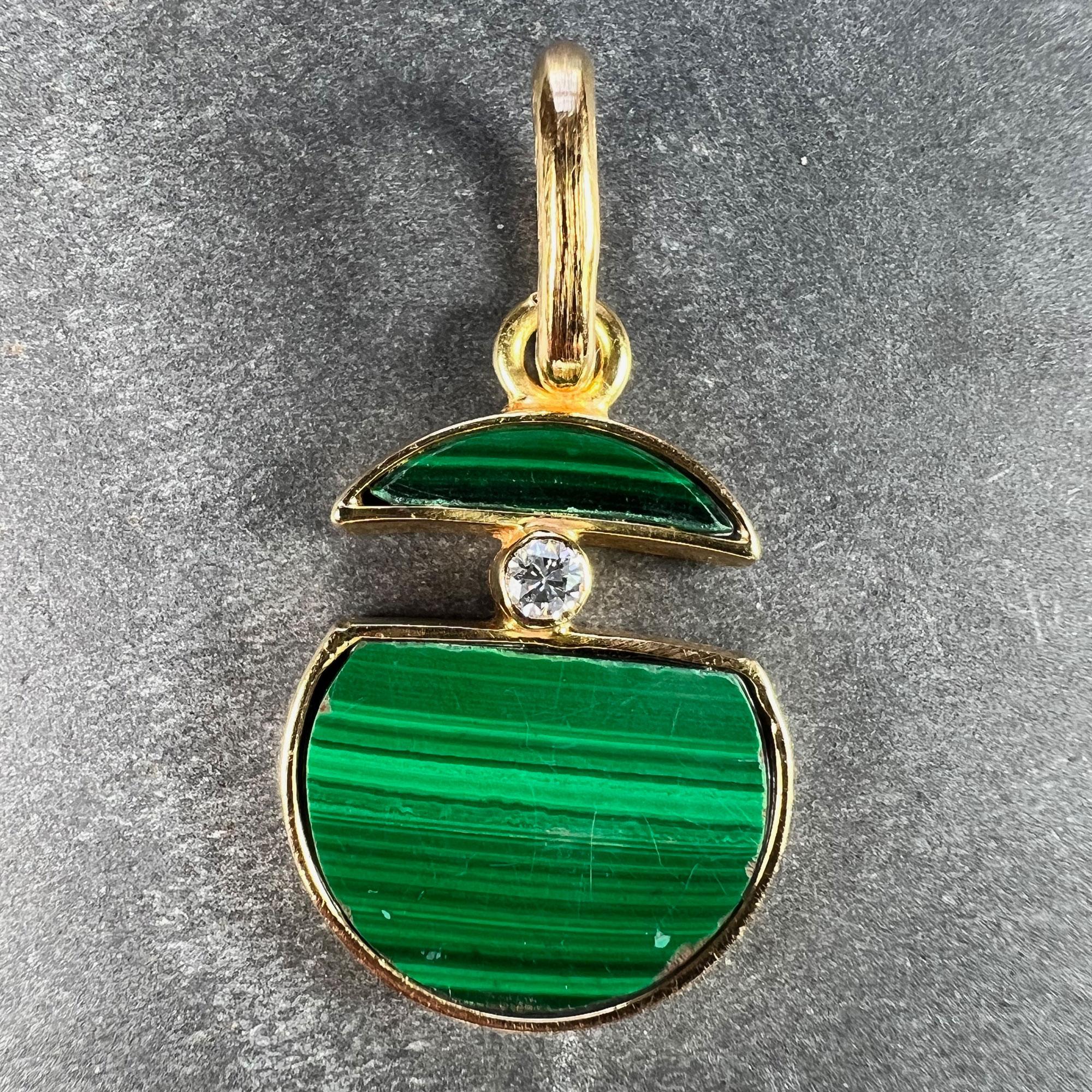 Pendentif à charme en or jaune 18 carats (18K) conçu comme un cercle fendu de malachite verte polie, serti au centre de la section fendue d'un diamant rond de taille brillant pesant environ 0,12 carats. Estampillé de la marque du hibou pour l'or 18