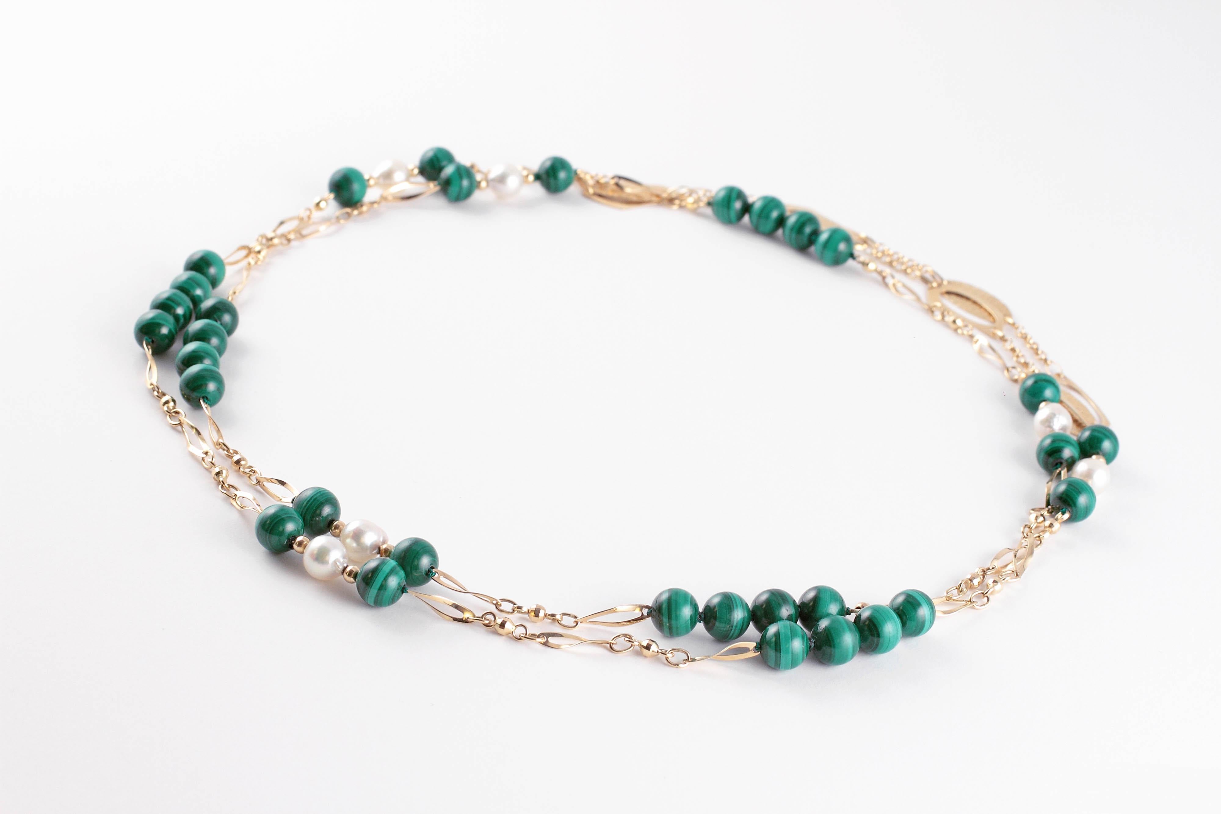 Beautiful and versatile!  Wear it as a long strand, or double it for a shorter look!  in 14 karat yellow gold, circular malachite beads alternate with freshwater pearls and yellow gold elongated, flat and circular links.