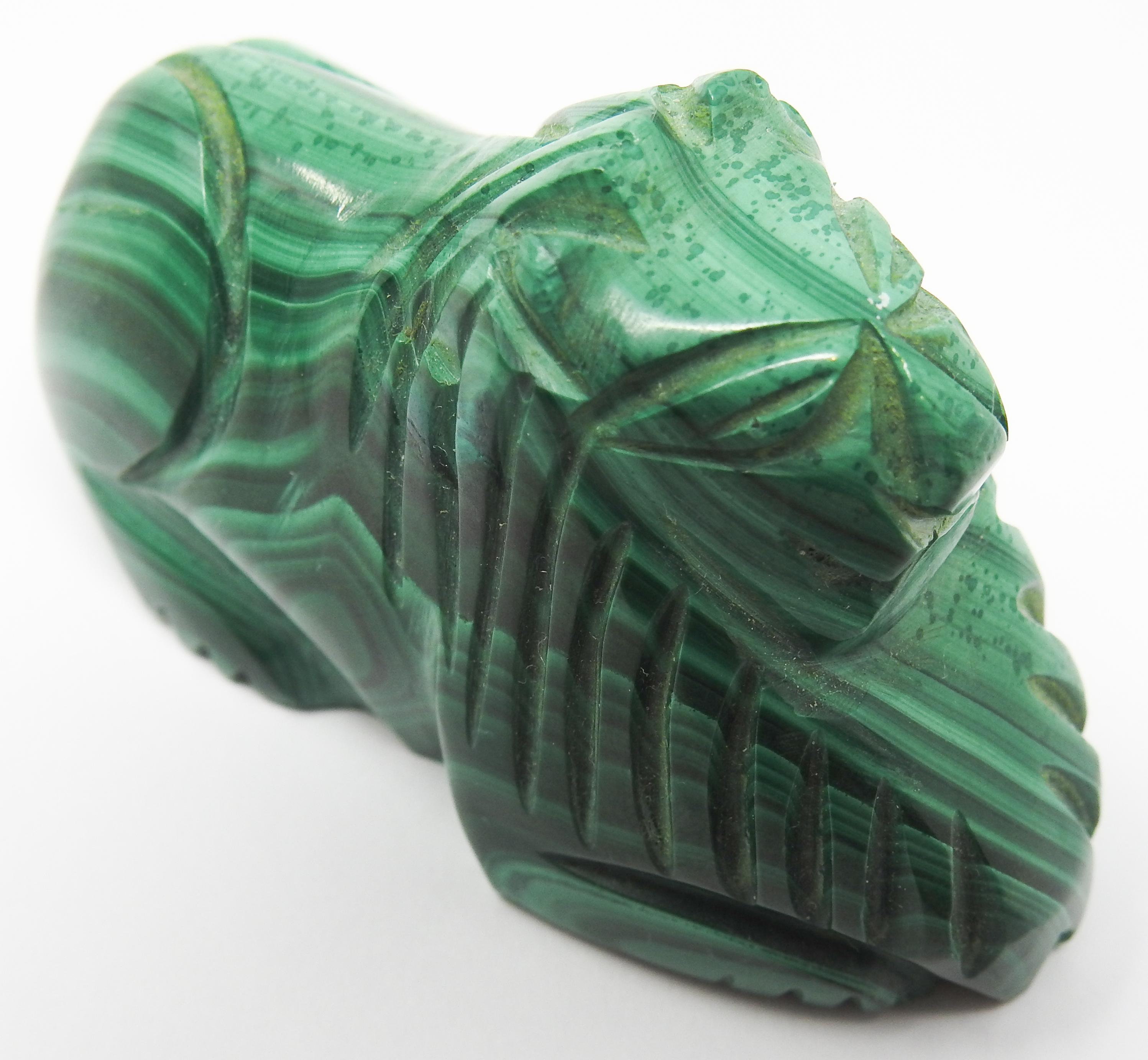 Offering this handsome Malachite lion. This small lion is hand carved with a handsome stone of malachite. Its green tones and simple lines that are carved make it an interesting piece.
