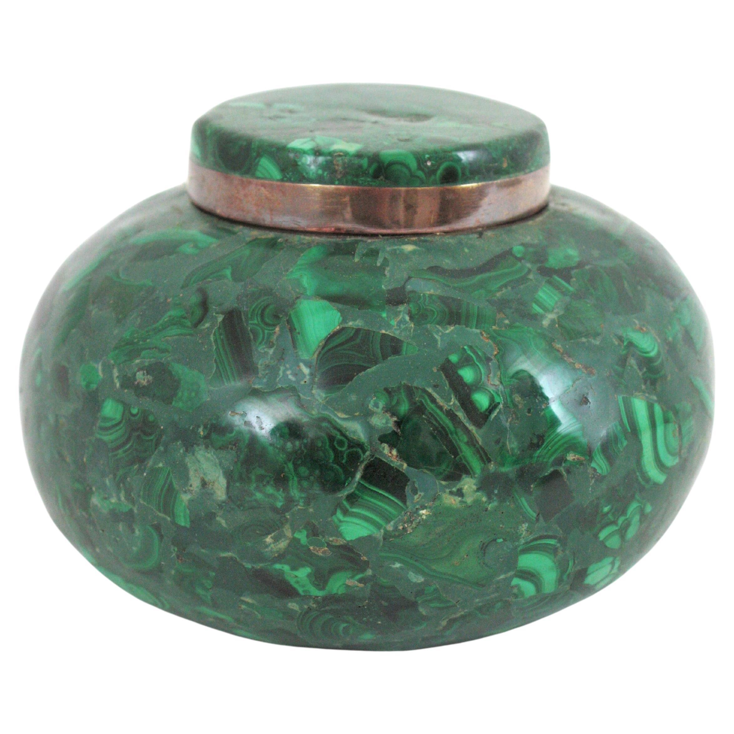 Hervorragende Mid-Century Modern Dose mit rundem Deckel aus Malachitstein, Spanien, 1950er Jahre.
Diese exquisite kugelförmige Schachtel aus den 1950er Jahren ist ganz aus Malachit gefertigt und hat einen Messingrand am Deckel und an der