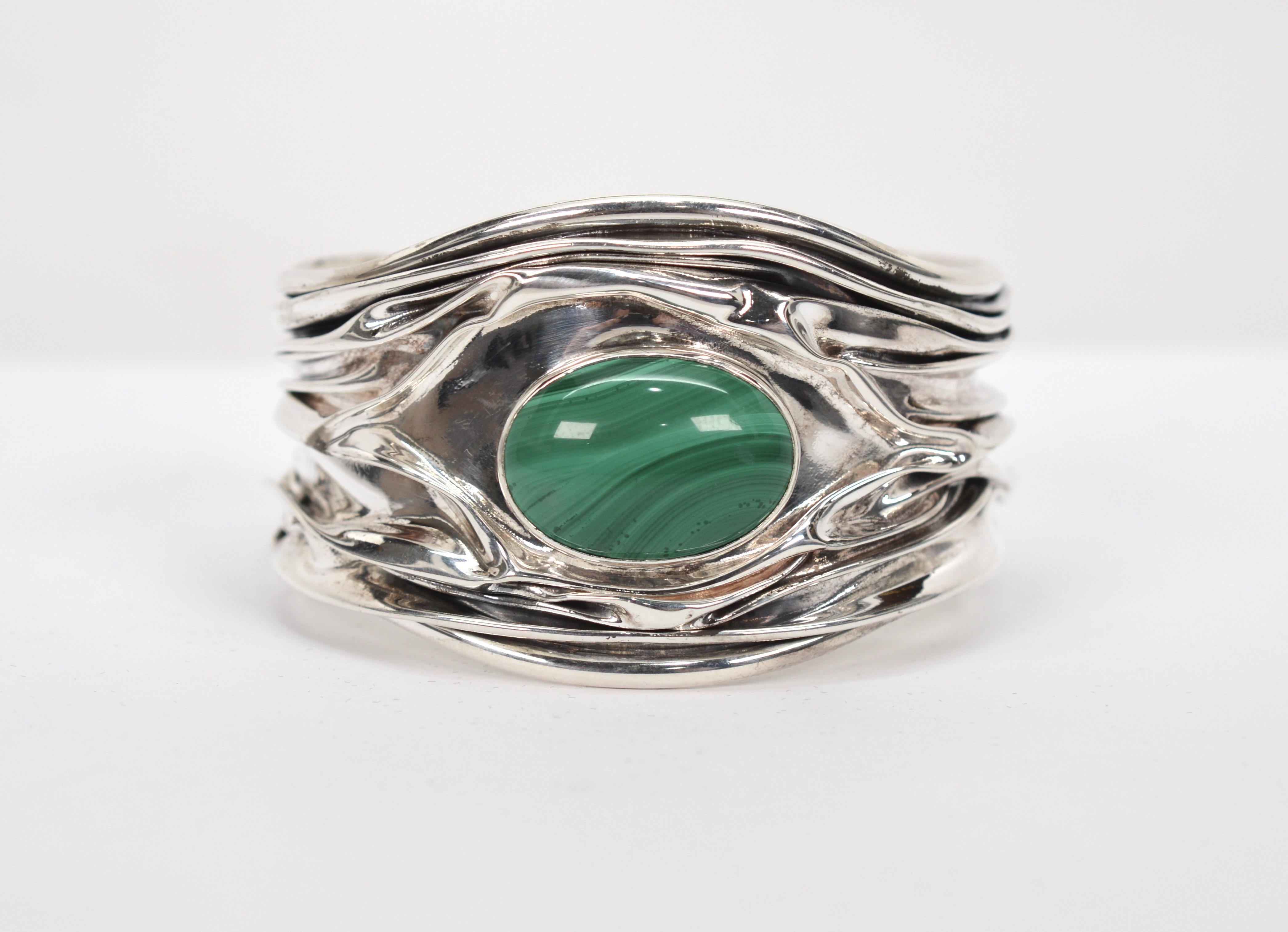 Folds of sterling silver crafted in an unique crinkle design give this cuff bracelet a unique textured and dimensional look.
Artisan created, the cuff features a bezel set oval-shaped green malachite polished stone nestled among the folds of silver