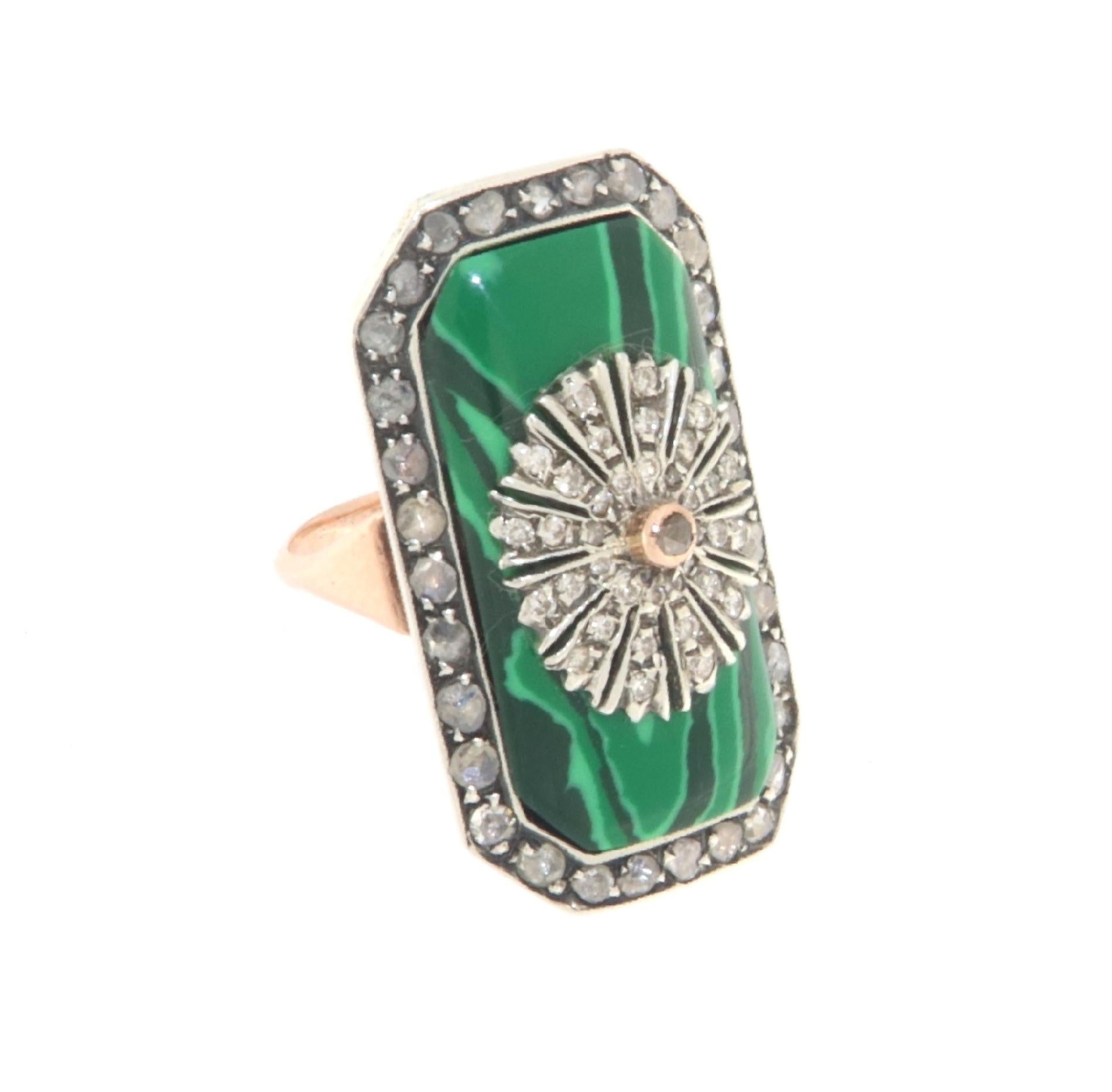 Spectacular ring made of 14 Karat yellow gold and 800 thousandths silver.

The front part of the ring is decorated with a silver frame where antique rose-cut diamonds are set which contains a splendid malachite on which another decoration with