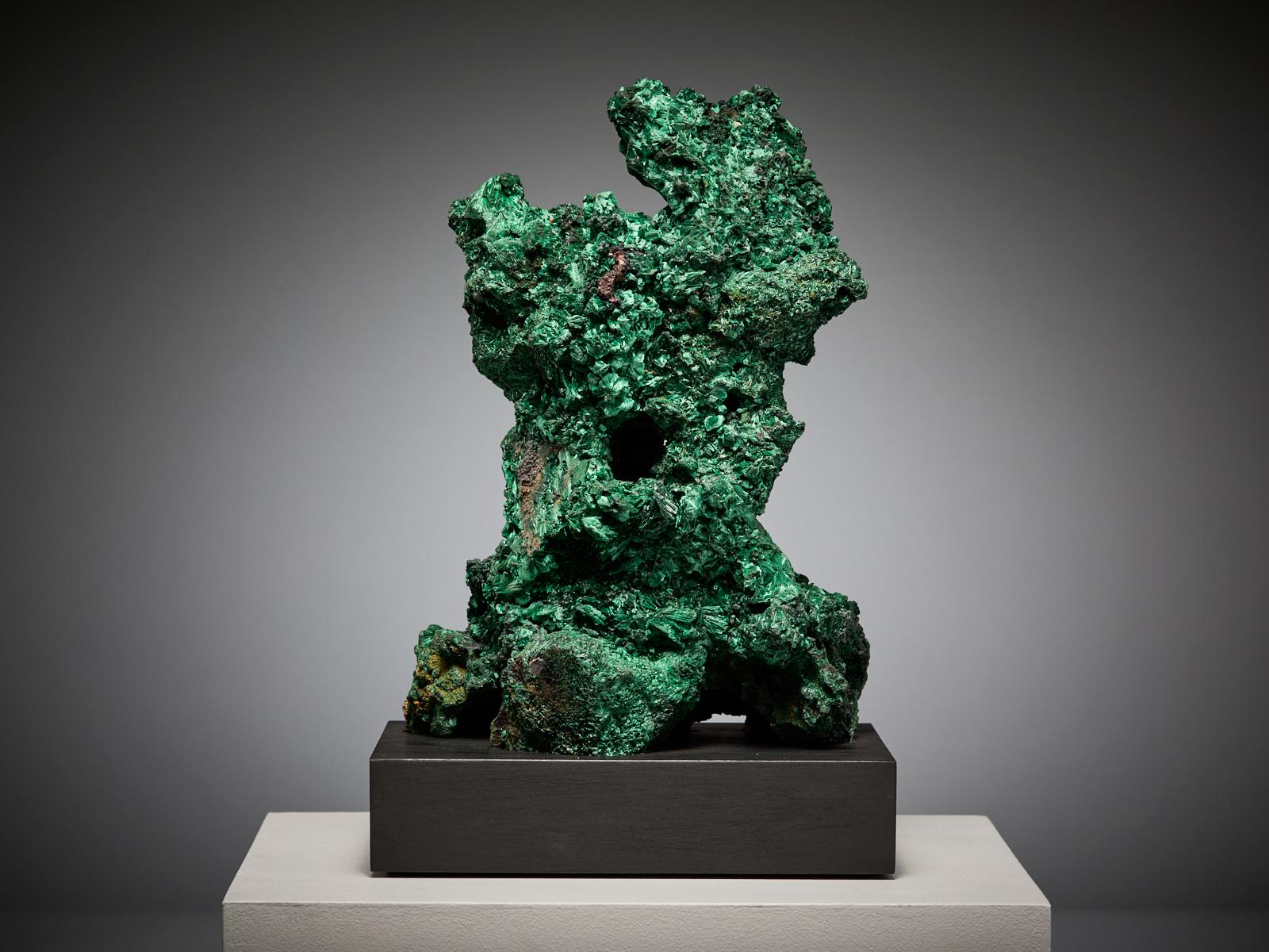This extraordinary malachite specimen from the Congo displays a breathtaking sculptural form, with layers of velvety green crystals that resemble a lush, natural landscape. The surface reveals a variety of shades, from deep forest to vibrant