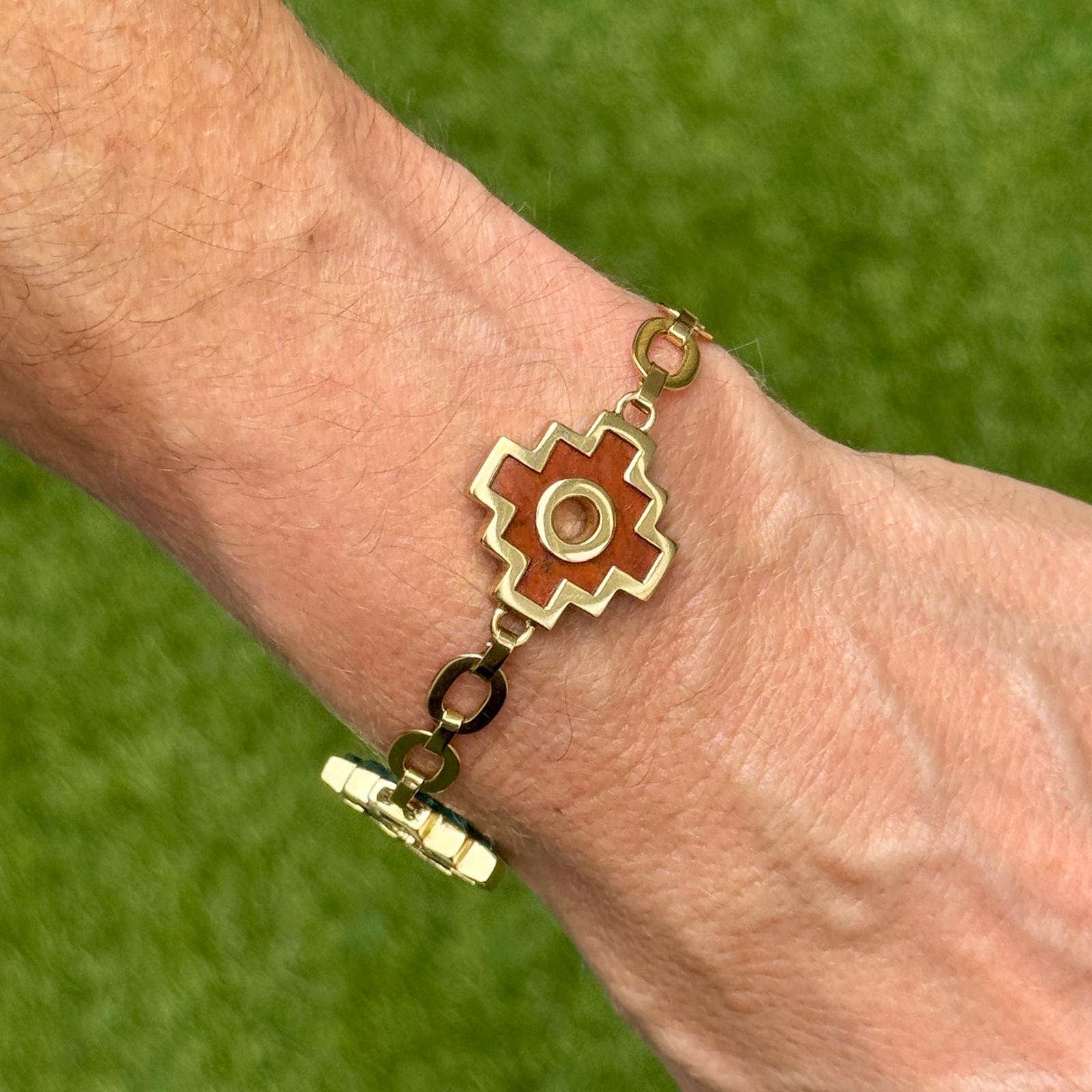Cet élégant bracelet est réalisé en or jaune 18 carats et présente une alternance de stations Chakana de 20 x 20 mm en malachite vibrante et en sodalite d'un bleu profond. Mesurant 7,5 pouces de long et fermée par un fermoir en forme de homard,